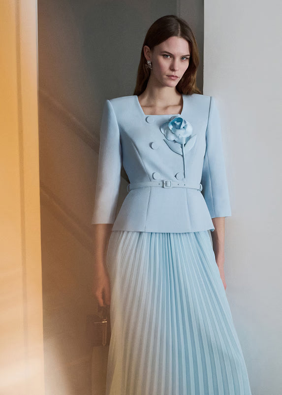 Woman wearing a light blue dress against a neutral background.