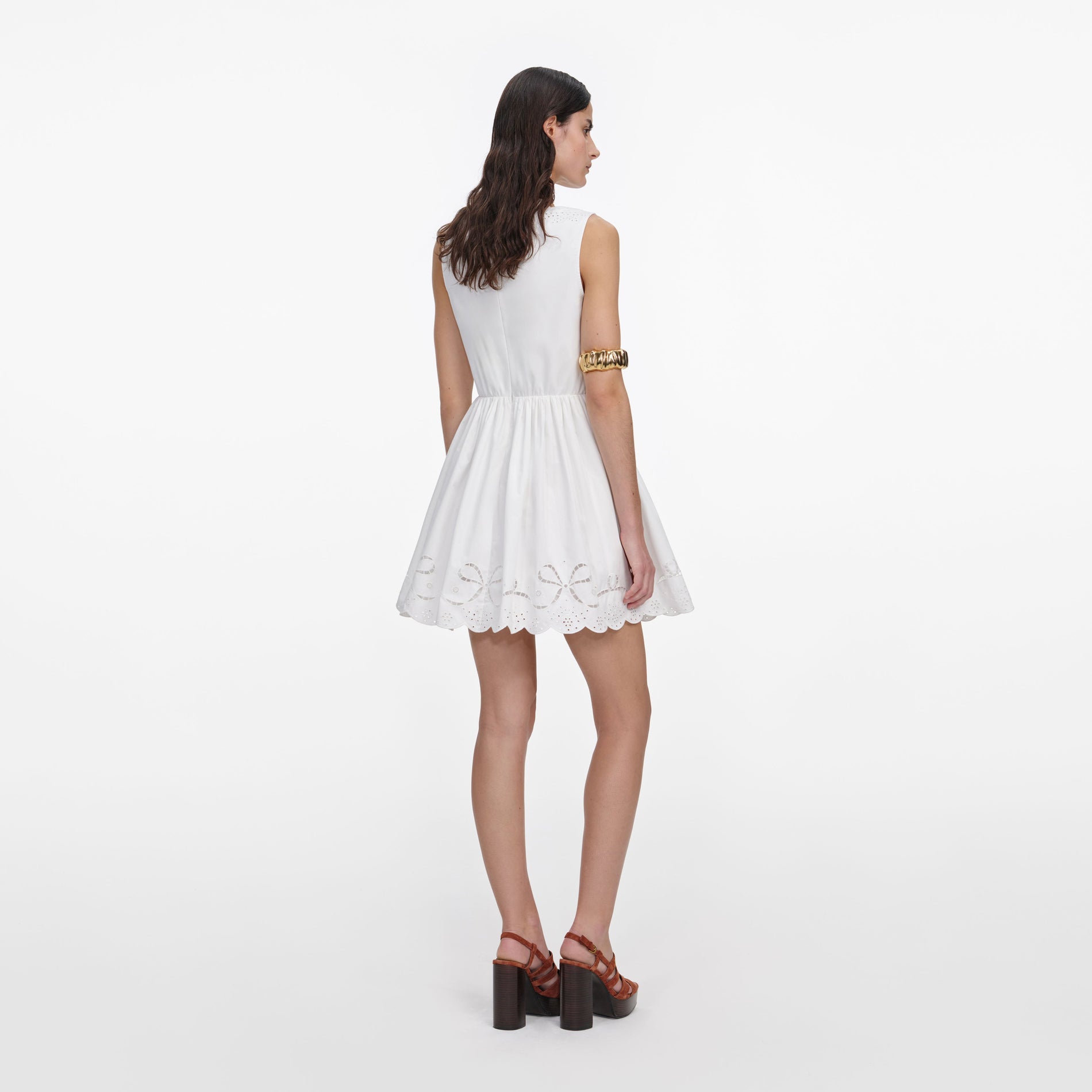 Back view of a woman wearing the White Cotton Embroidered Mini Dress