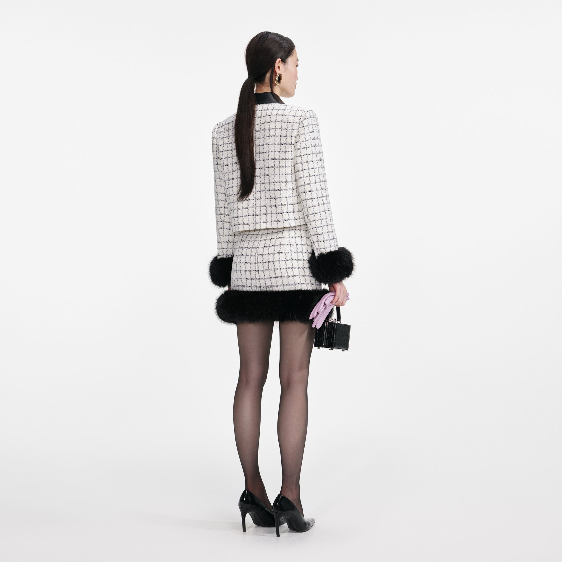 Back view of a woman wearing the Check Boucle Fur Hem Mini Skirt