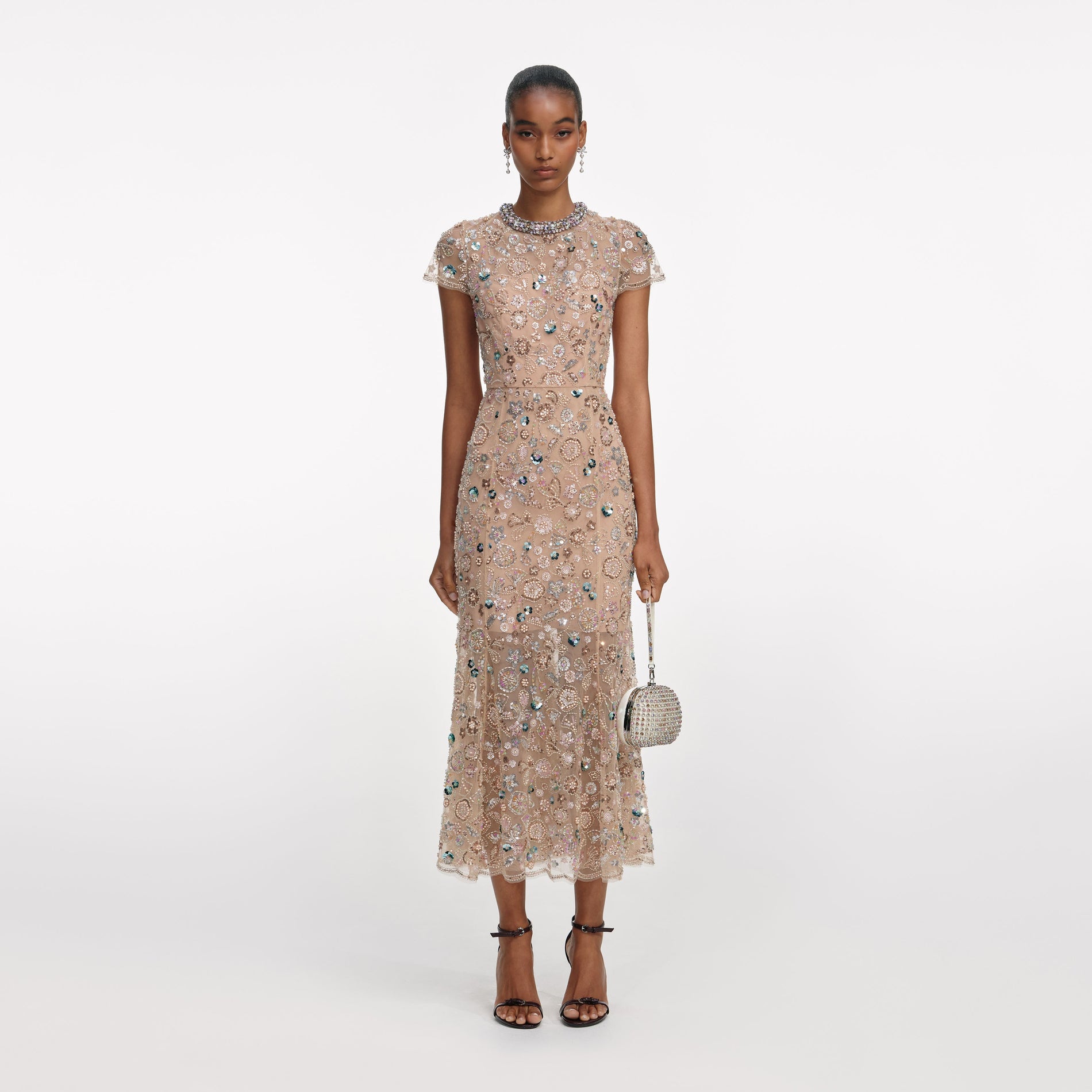 Model wearing a short sleeve midi dress with all-over floral sequin embroidery and a crystal embellished neckline