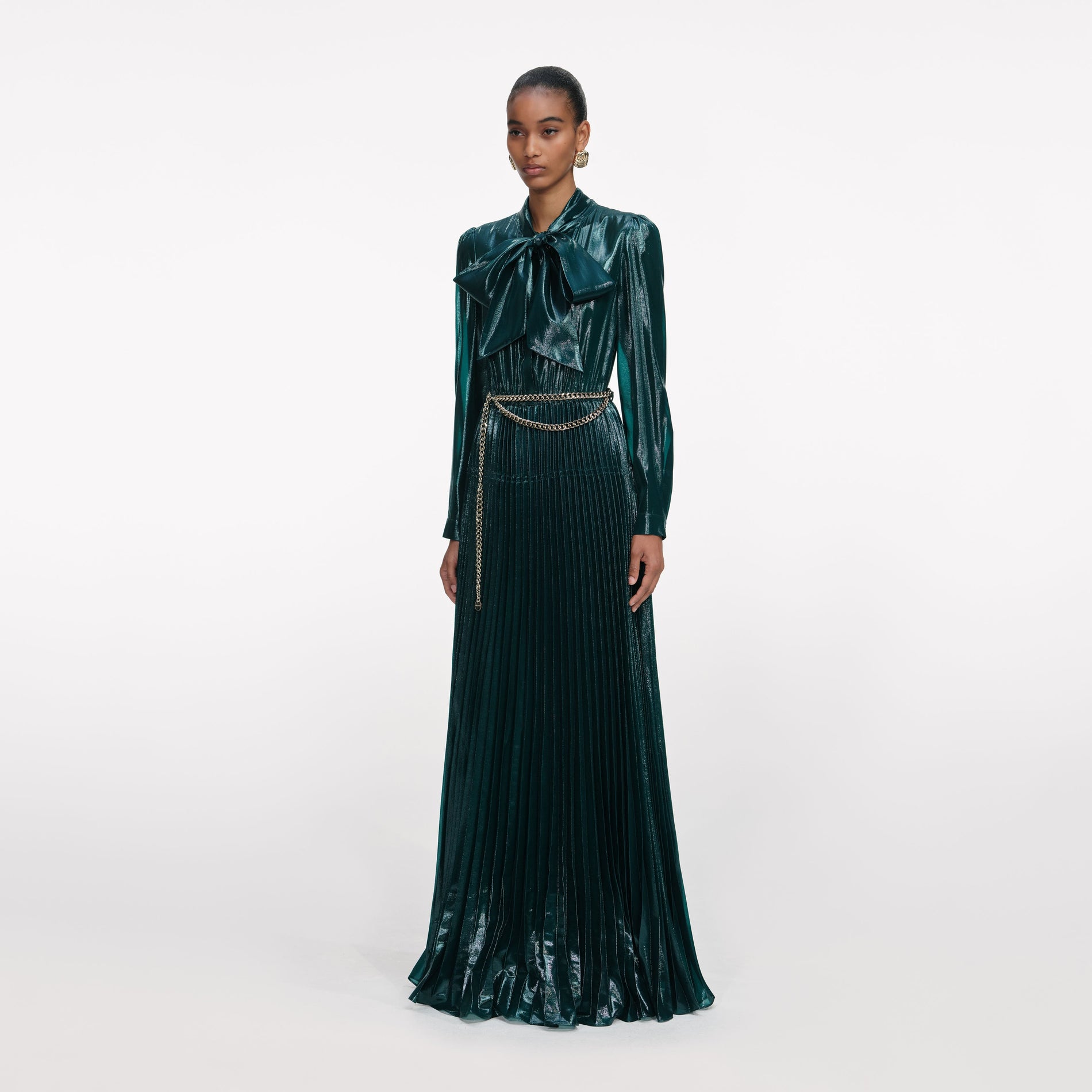 Side view of a woman wearing the Green Metallic Pussy Bow Maxi Dress