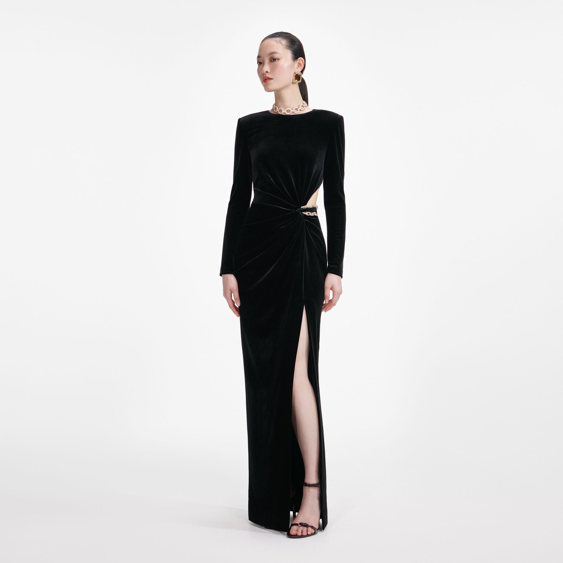 Side view of a woman wearing the Black Velvet Embellished Maxi Dress