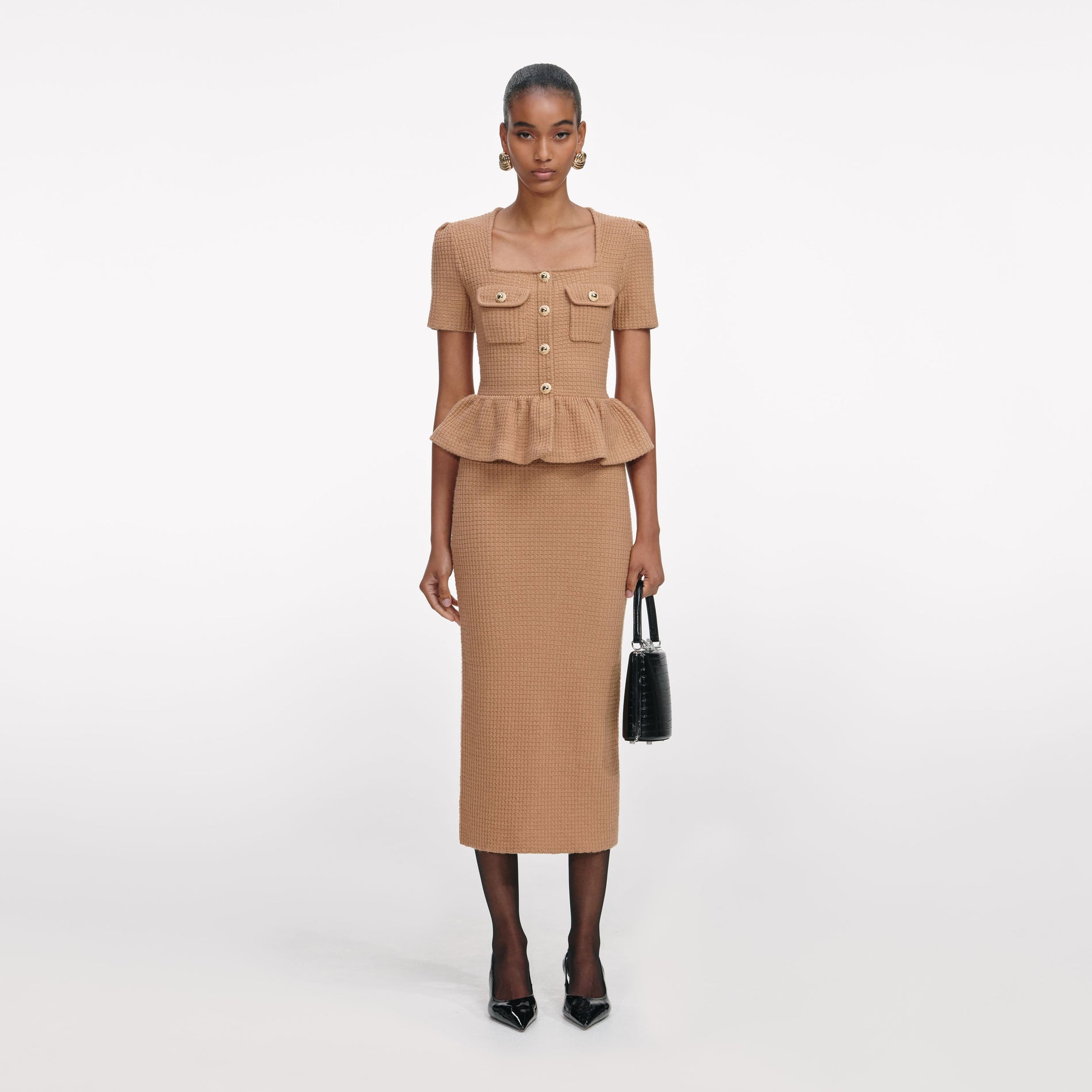 Front view of a woman wearing the Camel Peplum Knit Midi Dress