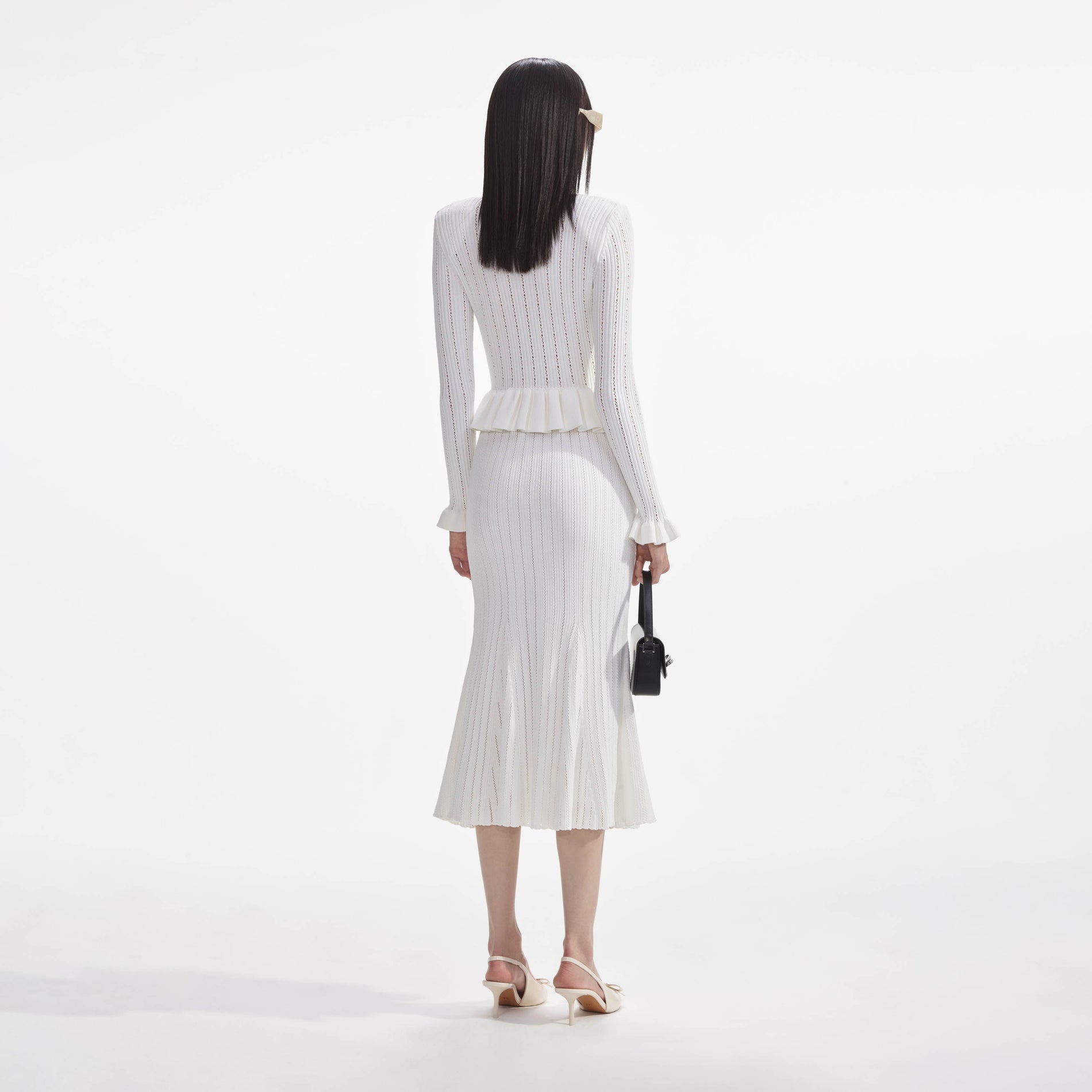 Back view of a woman wearing the White Knit Peplum Midi Dress