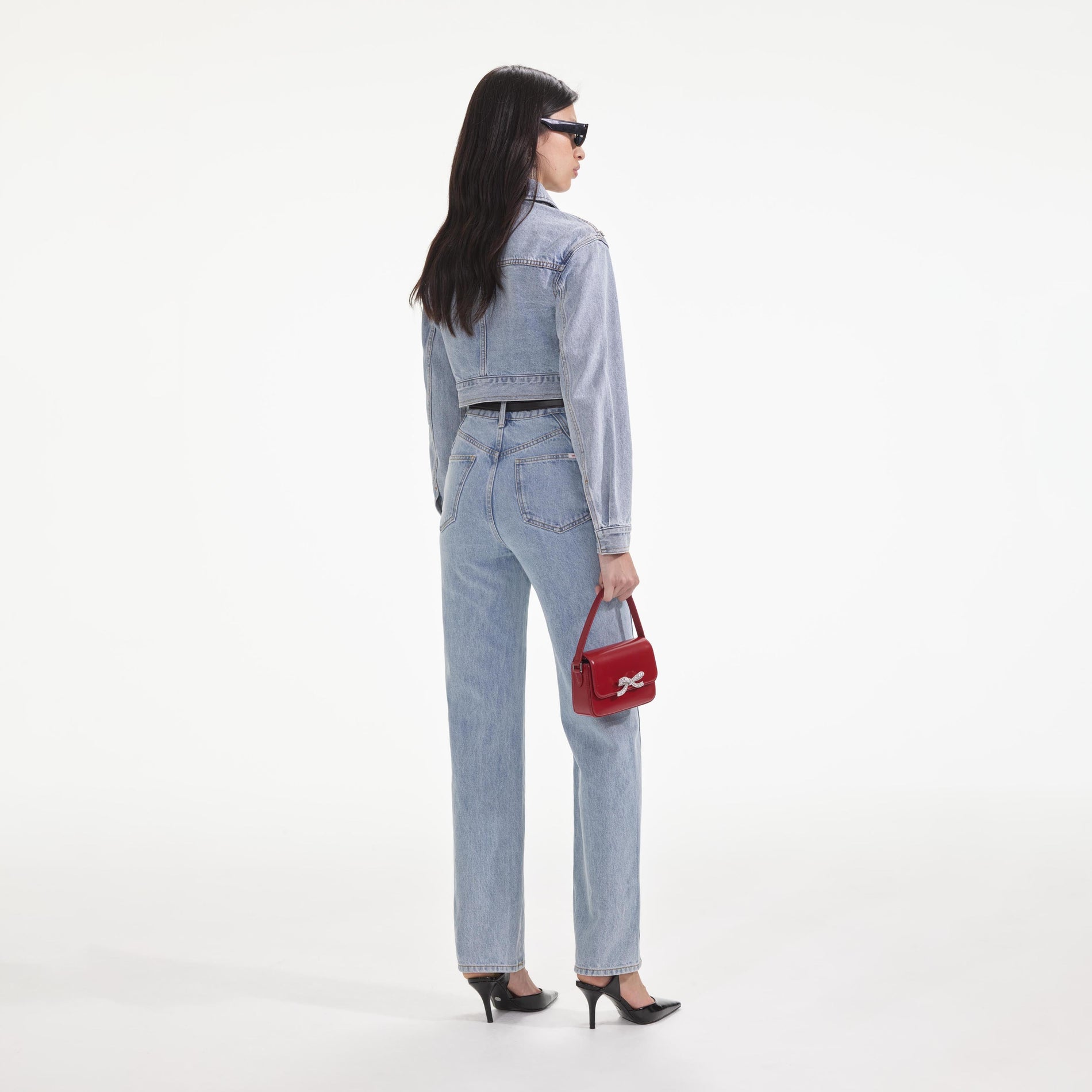 Back view of a woman wearing the Crystal Embellished Denim Jacket