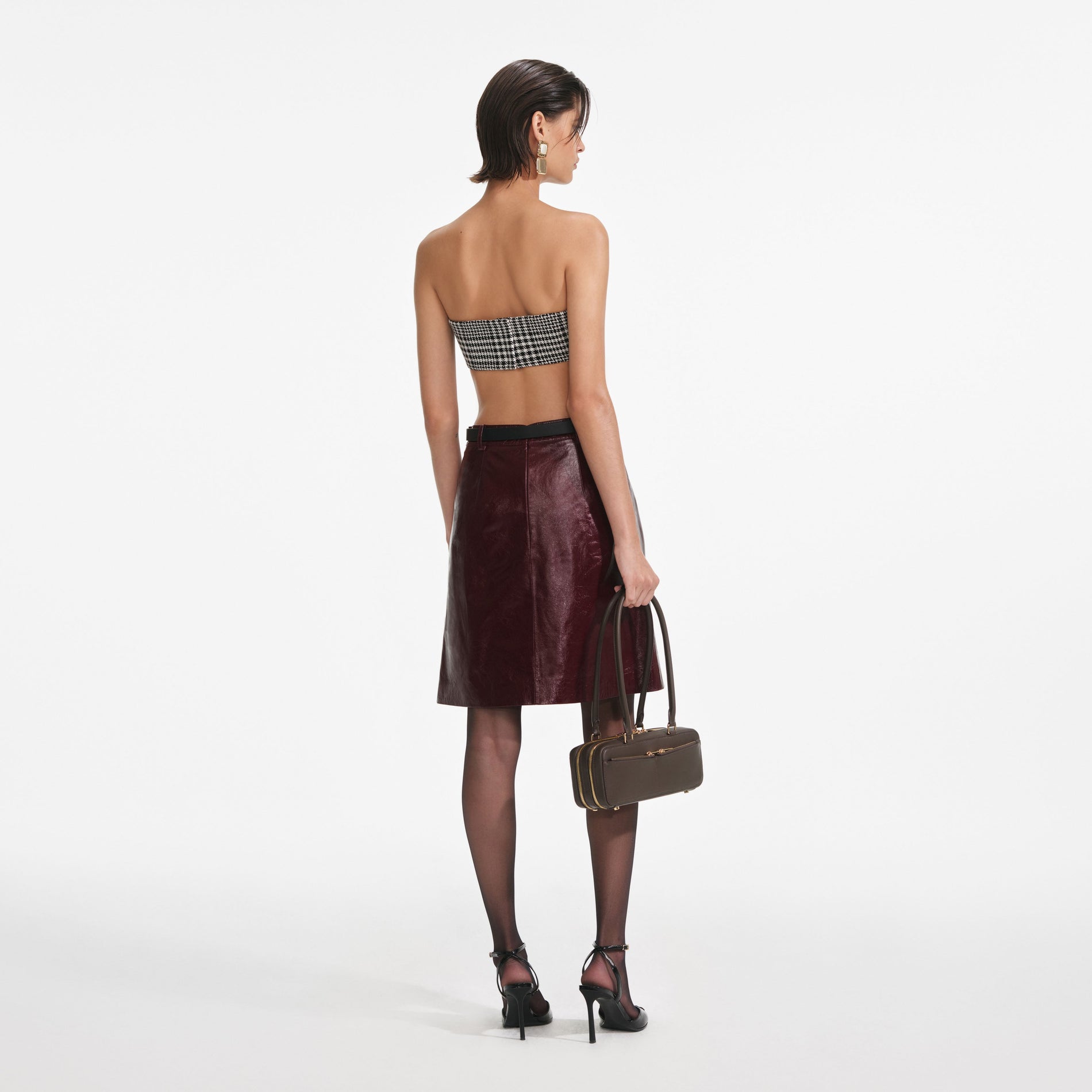 Back view of a woman wearing the Burgundy Leather Mini Skirt