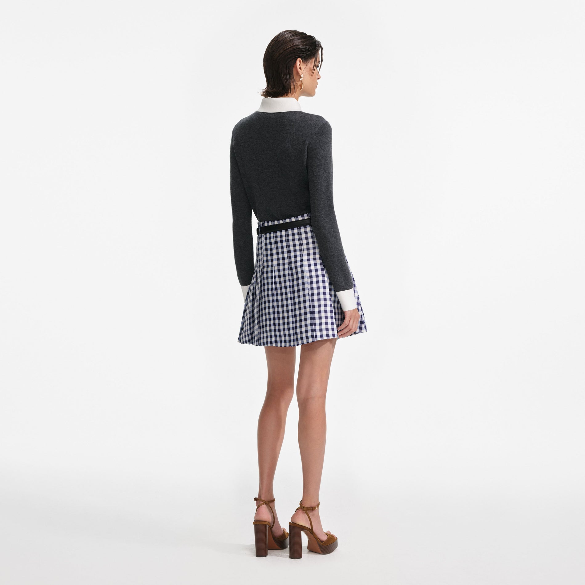 Back view of a woman wearing the Navy Gingham Pleated Taffeta Mini Skirt
