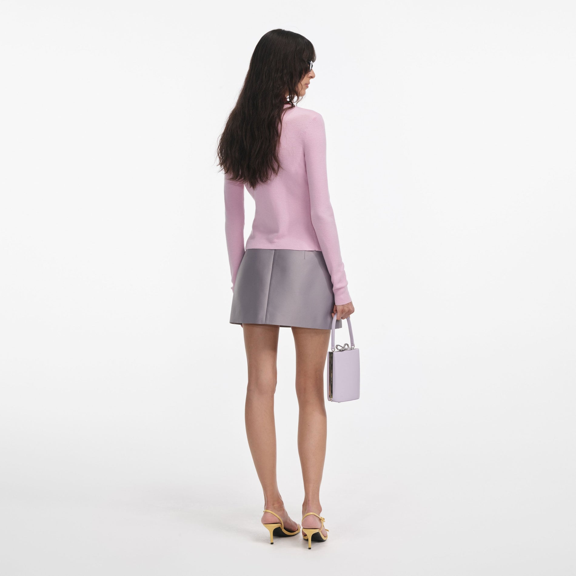 Back view of a woman wearing the Pink Merino Wool Cardigan