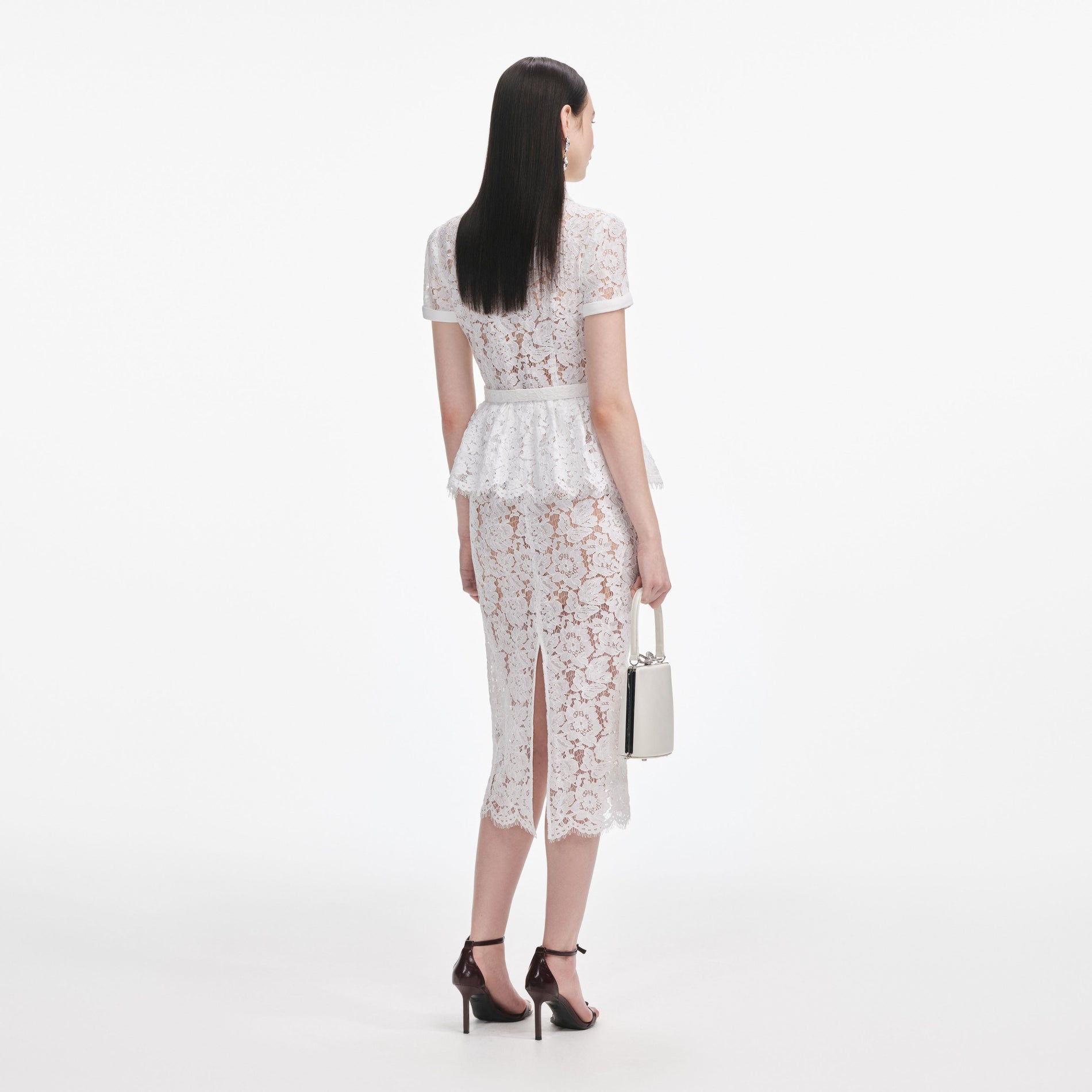 Back view of a woman wearing the White Lace Peplum Midi Dress