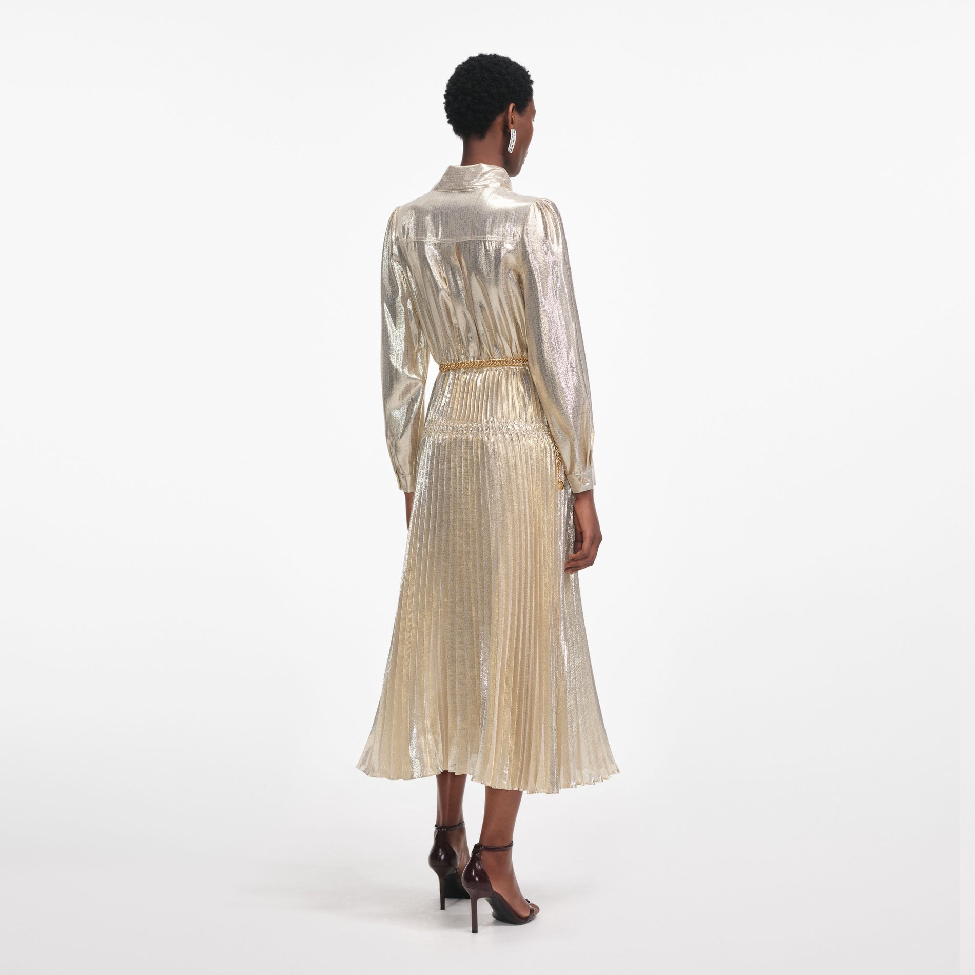 Back view of a woman wearing the Gold Metallic Pussy Bow Midi Dress