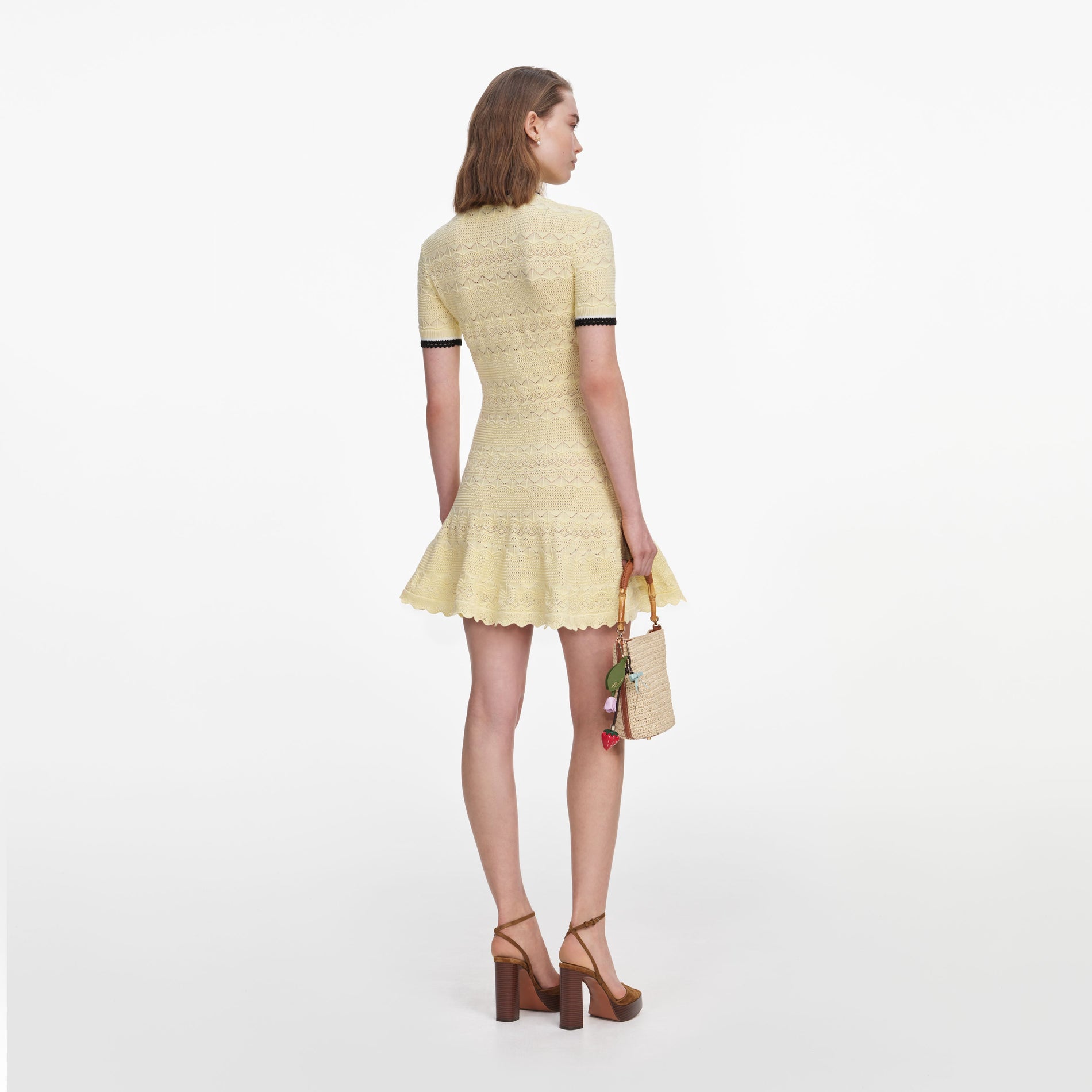 Back view of a woman wearing the Yellow Pointelle Knit Mini Dress