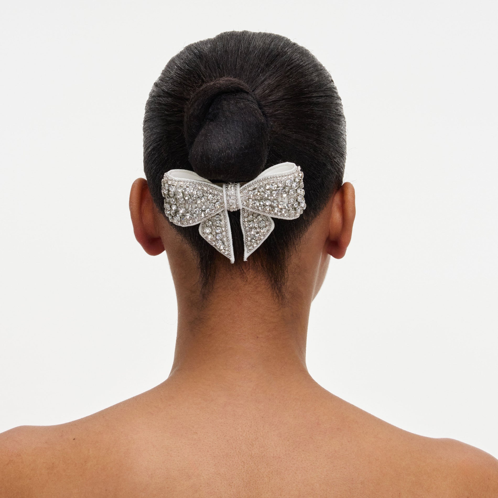 A close up of a woman wearing the Crystal Embellished Bow Hairclip