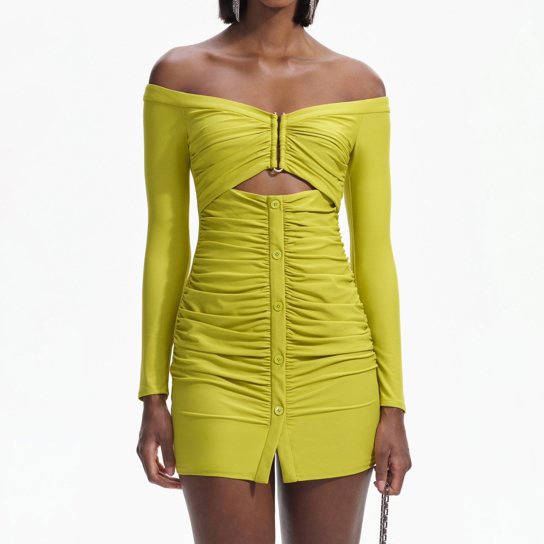 A close up of a woman wearing the Chartreuse Off Shoulder Mini Dress
