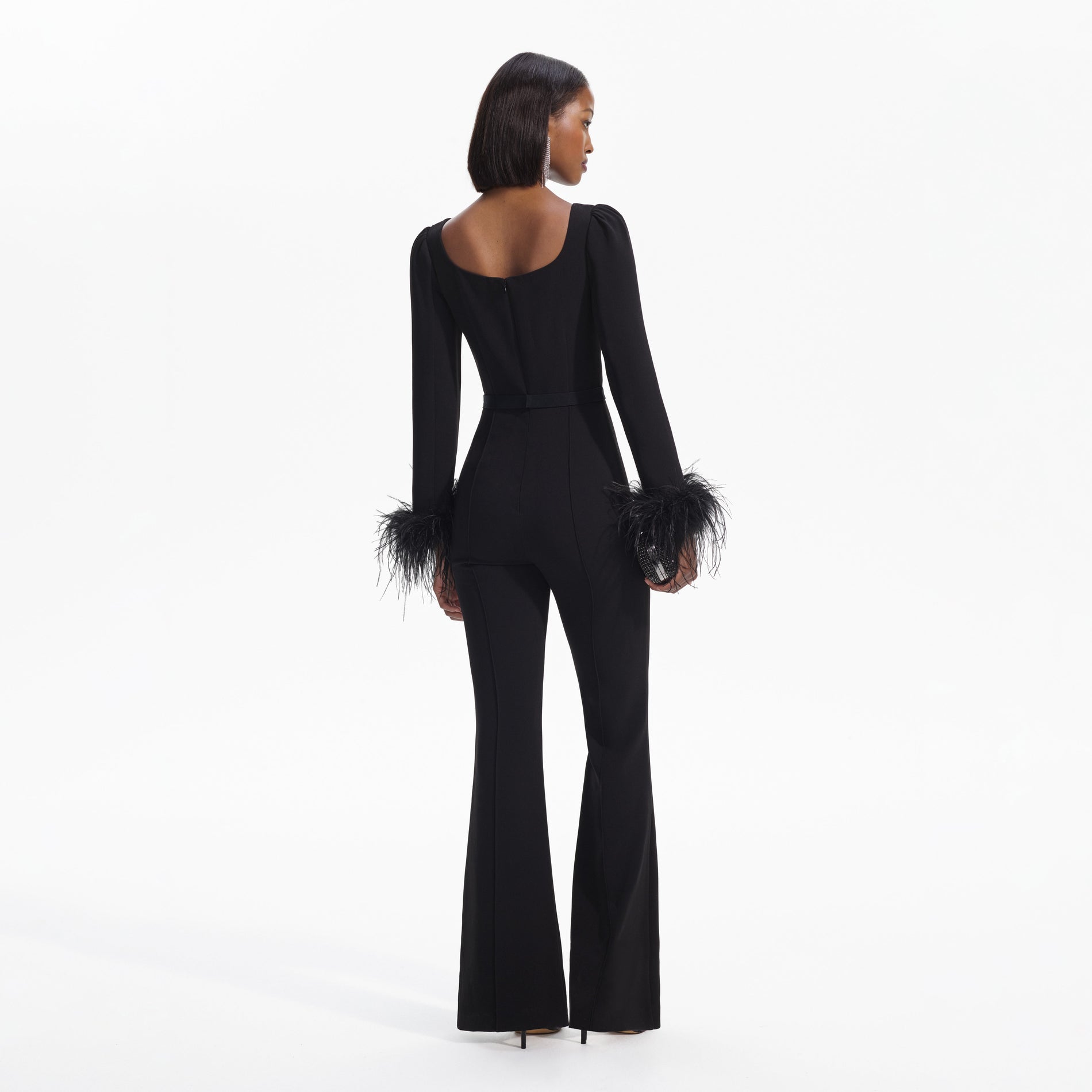 Back view of a woman wearing the Black Crepe Feather Jumpsuit