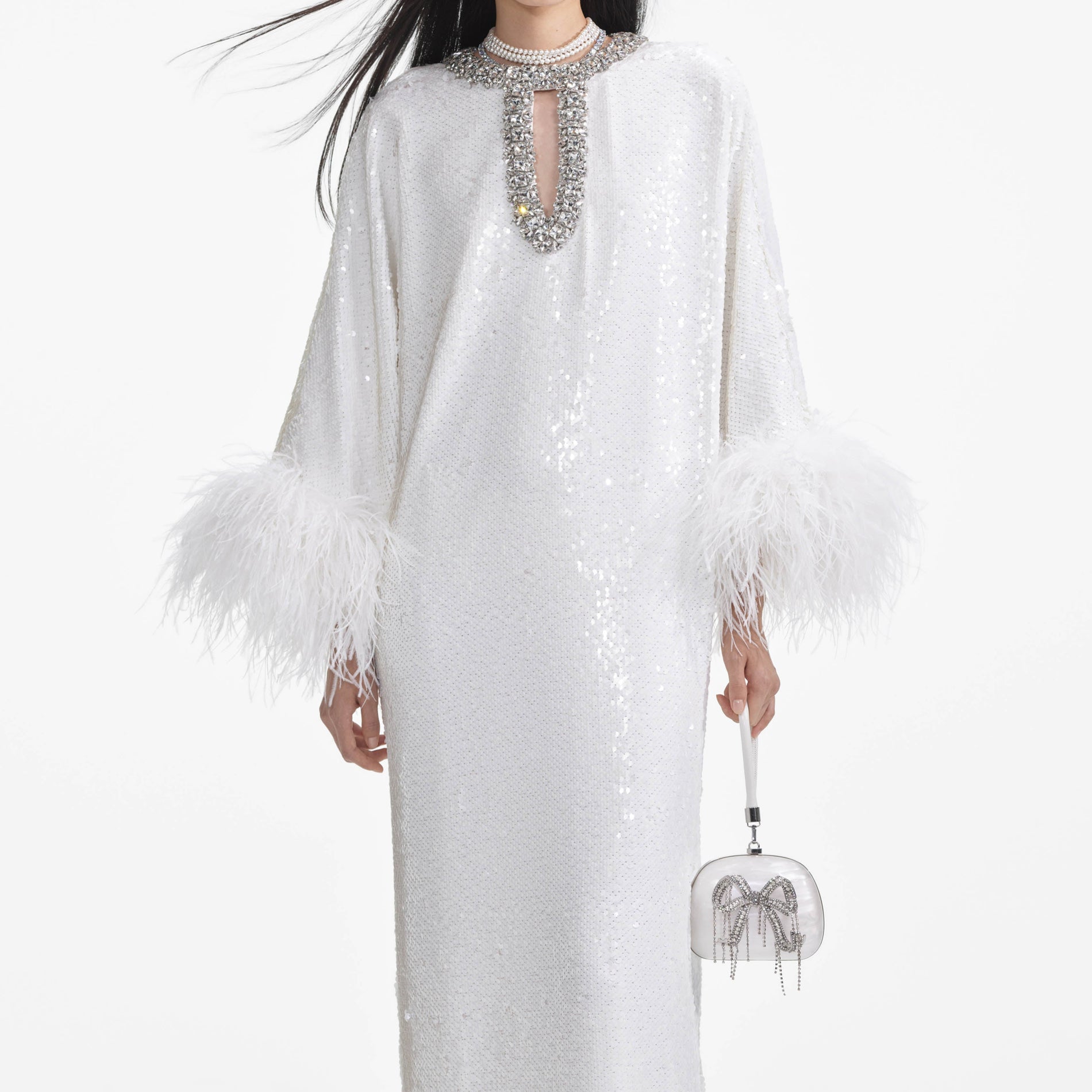 A close up of a woman wearing the White Sequin Feather Maxi Dress