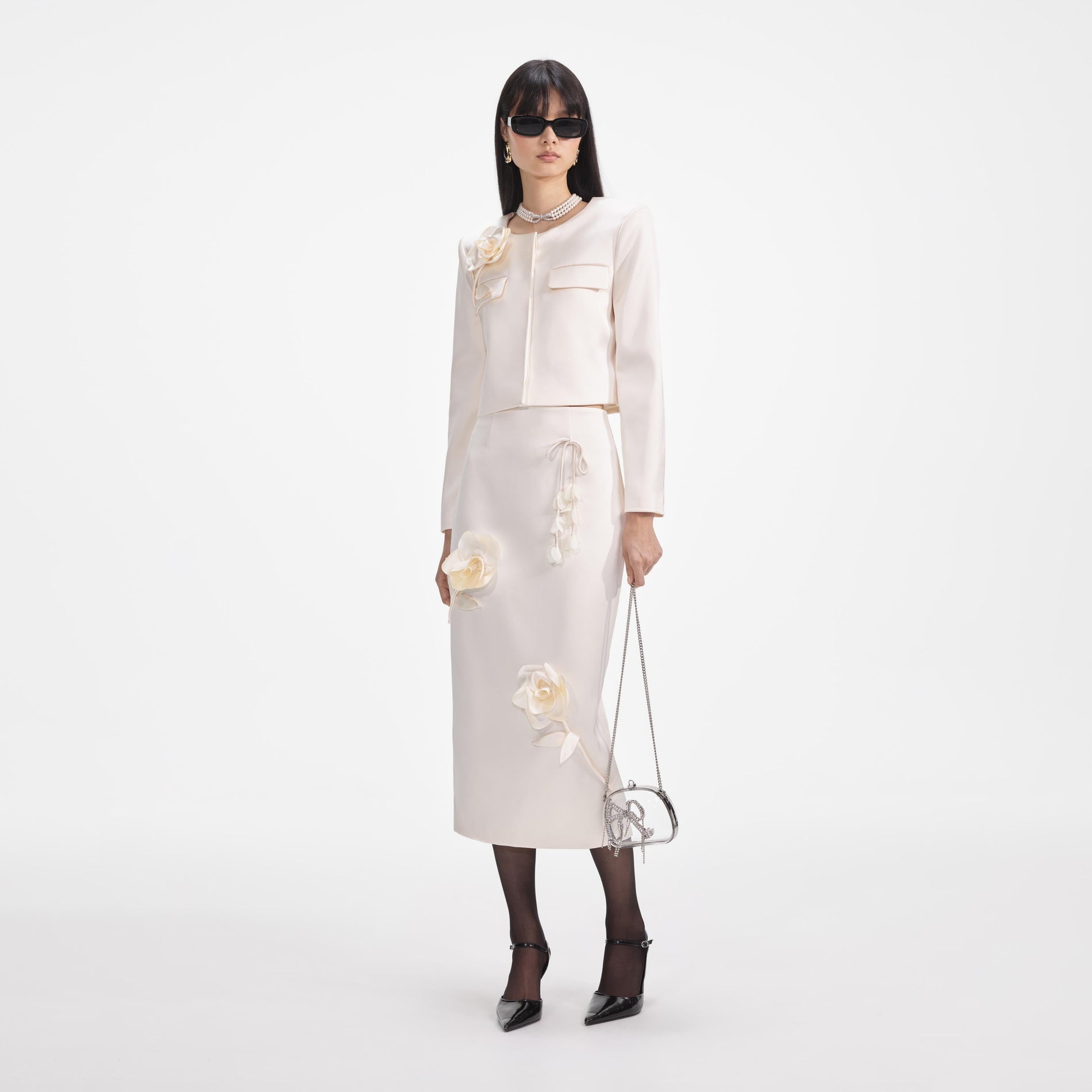 Side view of a woman wearing the Cream 3D Flower Satin Midi Skirt