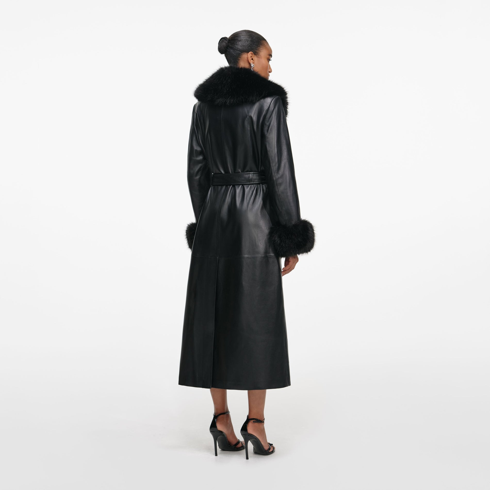 Back view of a woman wearing the Black Leather Faux Fur Collared Coat