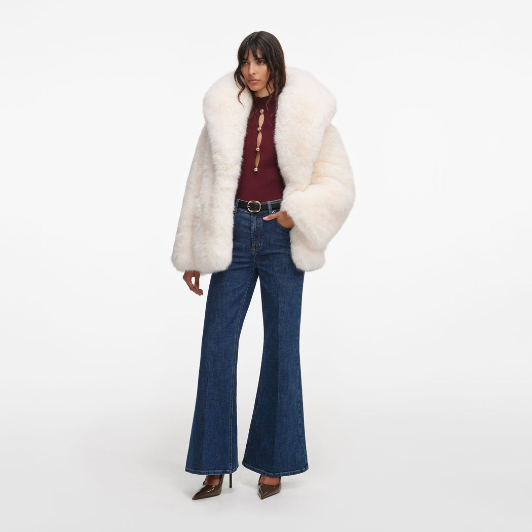 Side view of a woman wearing the White Faux Fur Coat