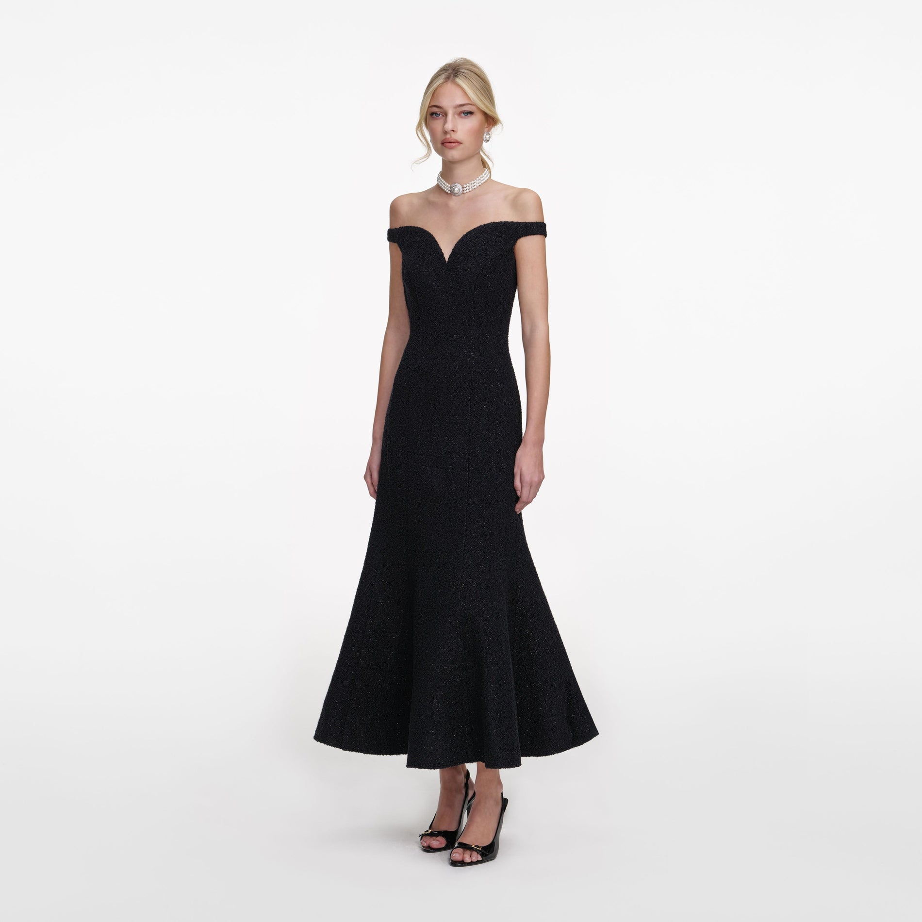 Side view of a woman wearing the Black Boucle Midi Dress