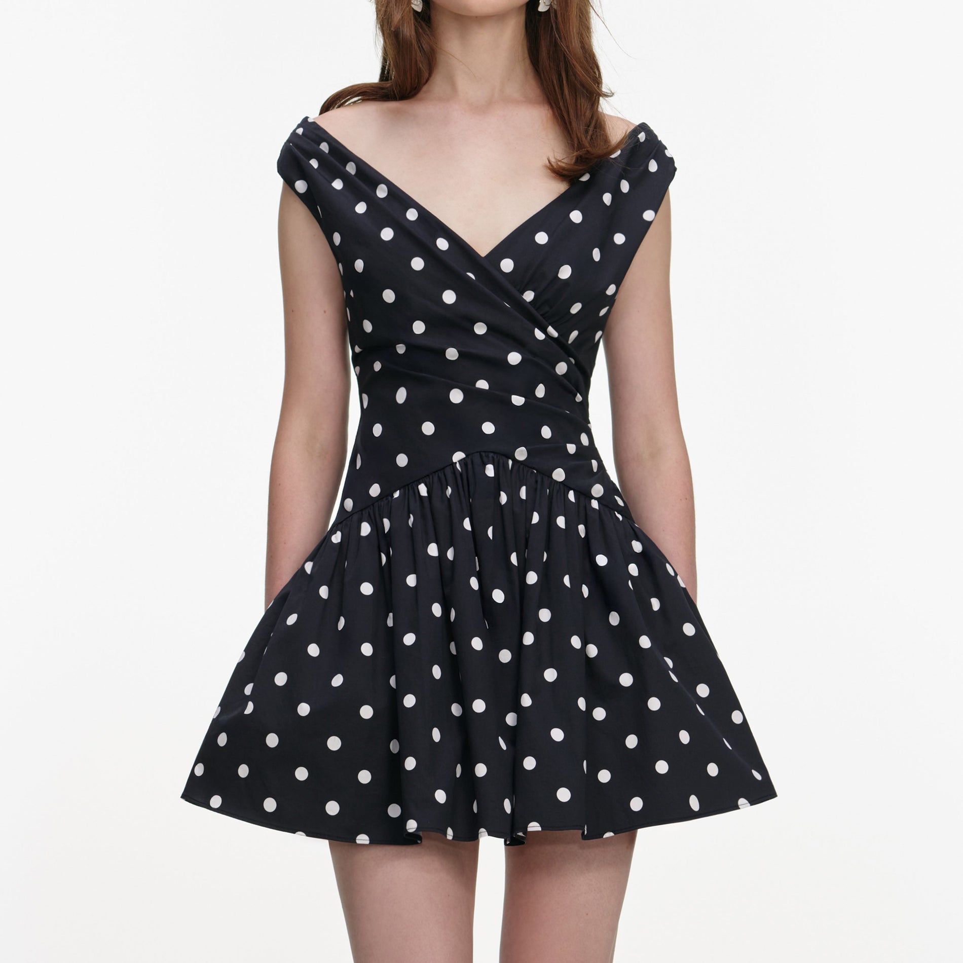 A close up of a woman wearing the Black Polka Dot Cotton Mini Dress