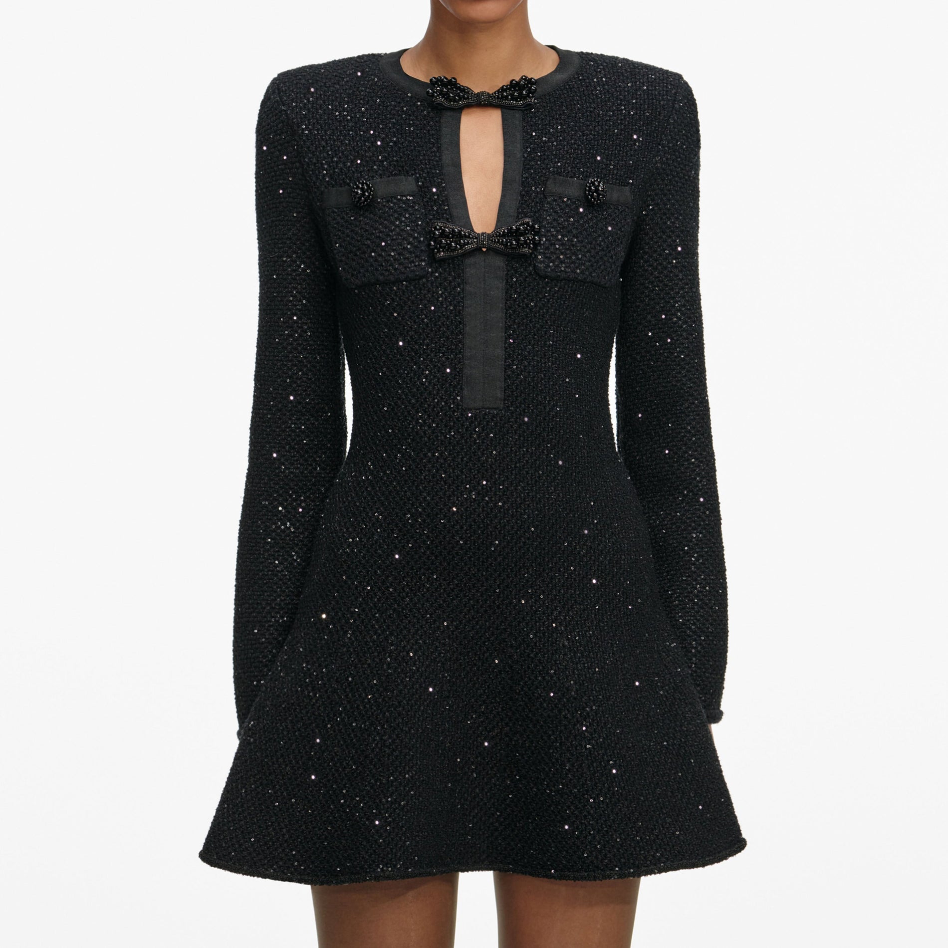 A close up of a woman wearing the Black Sequin Knit Mini Dress
