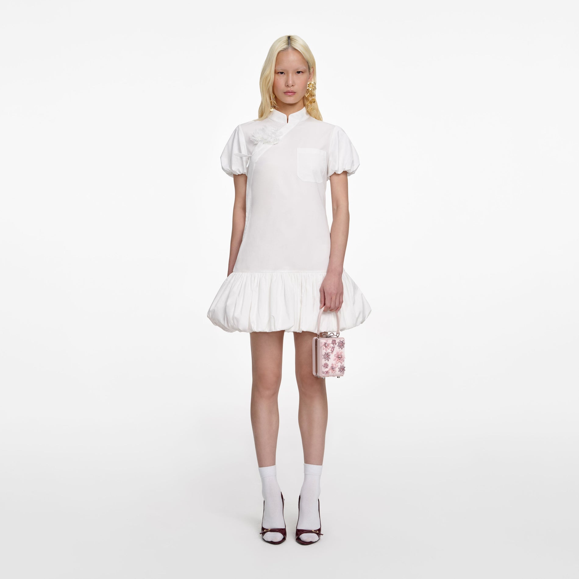 Front view of a woman wearing the White Cotton Asymmetric Mini Dress