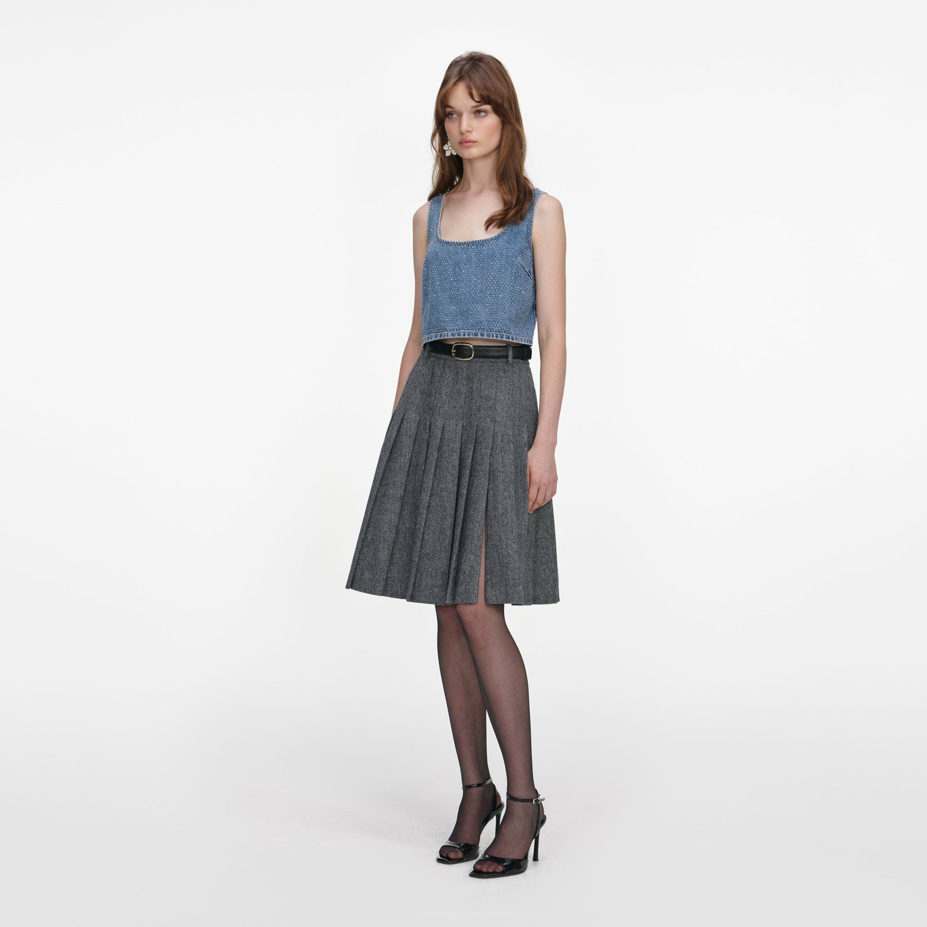 Side view of a woman wearing the Grey Herringbone Pleated Midi Skirt