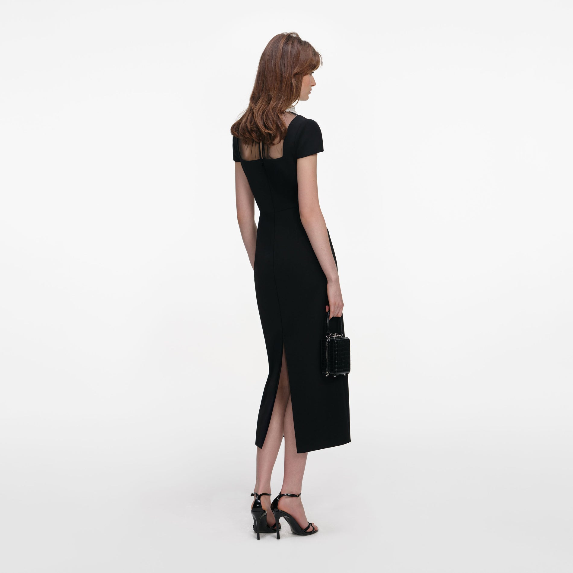 Back view of a woman wearing the Black Crepe Bow Collar Midi Dress