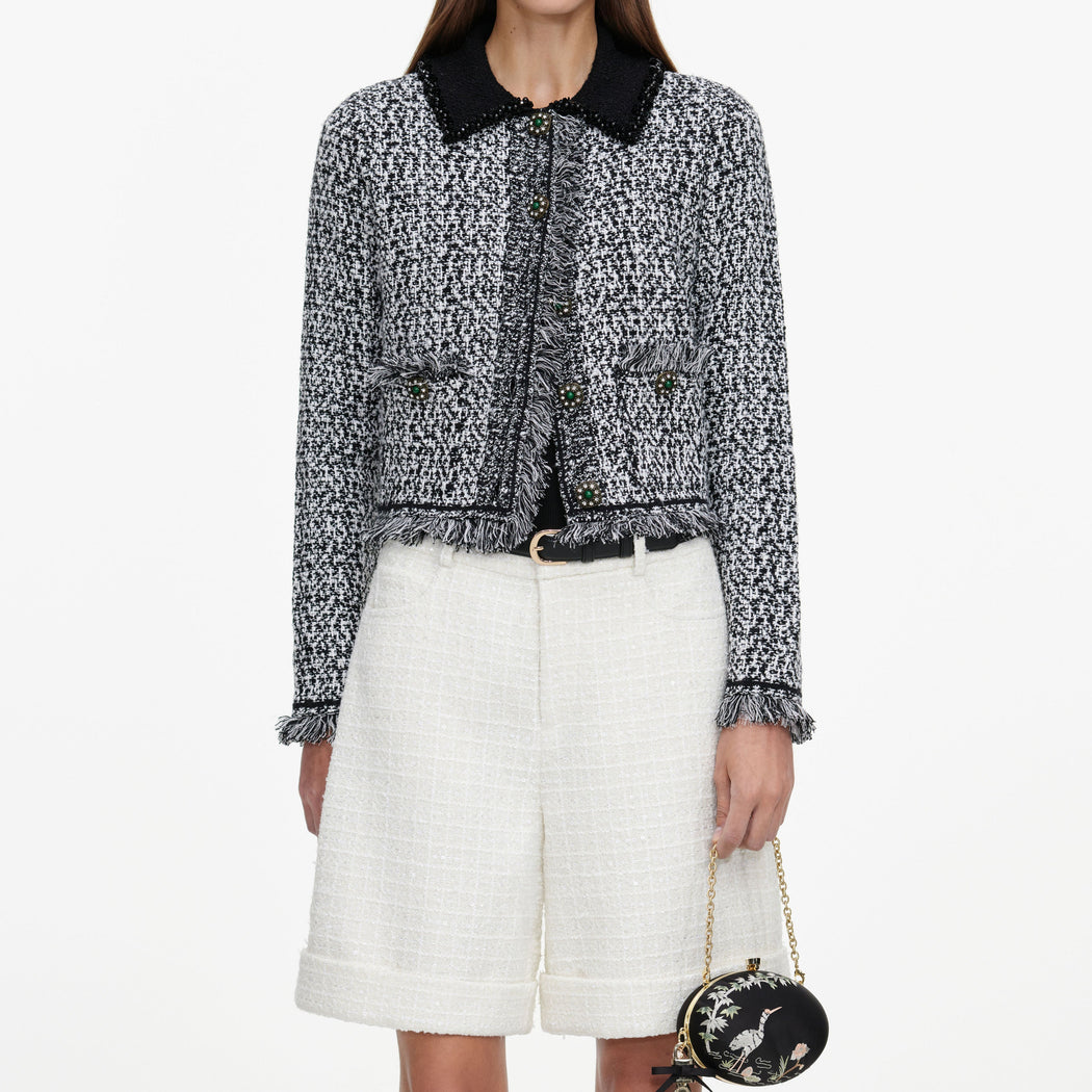 A close up of a woman wearing the Cream Sequin Boucle Tailored Shorts