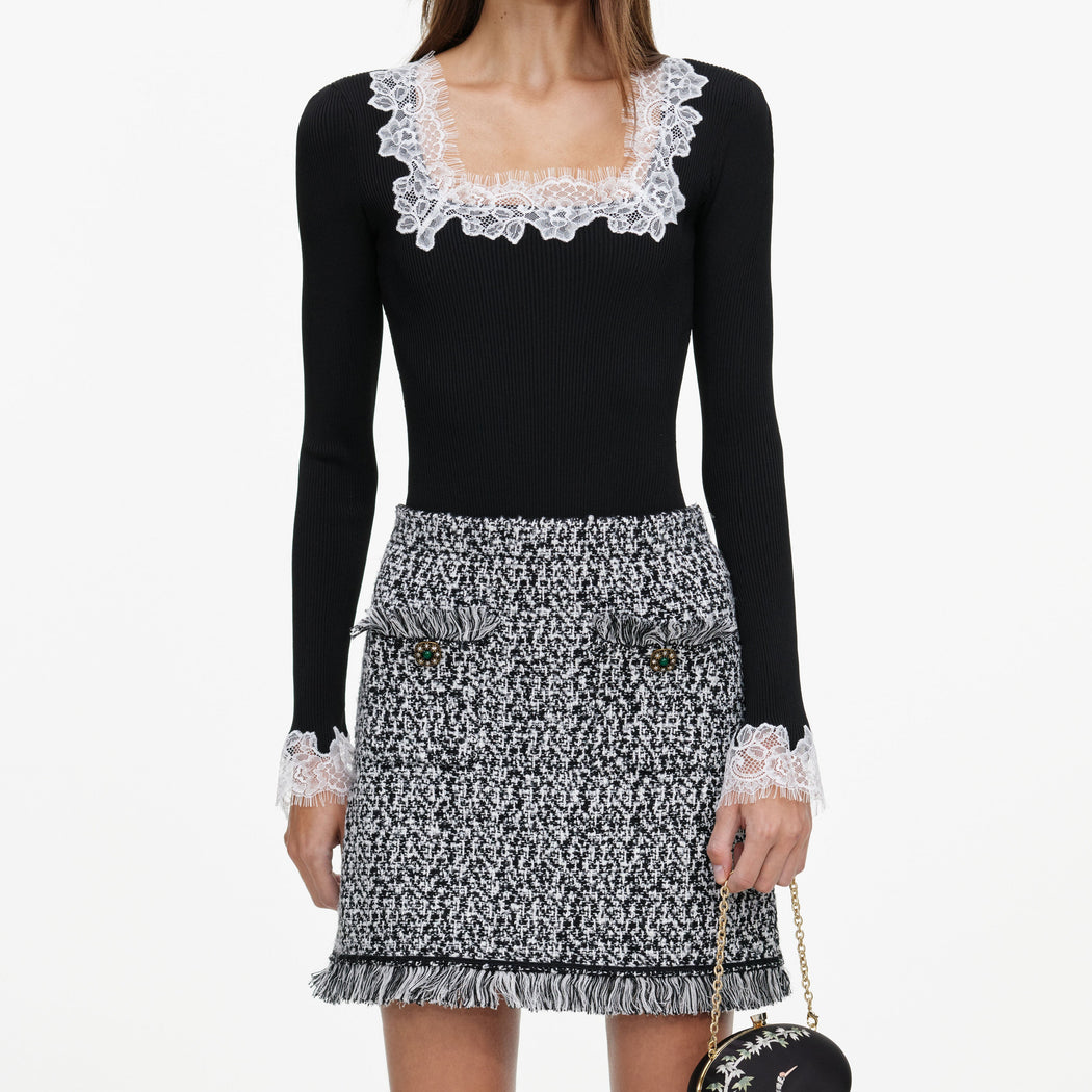 A close up of a woman wearing the Black And White Textured Knit Mini Skirt