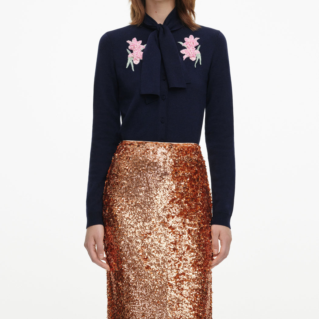 A close up of a woman wearing the Gold Sequin Midi Skirt