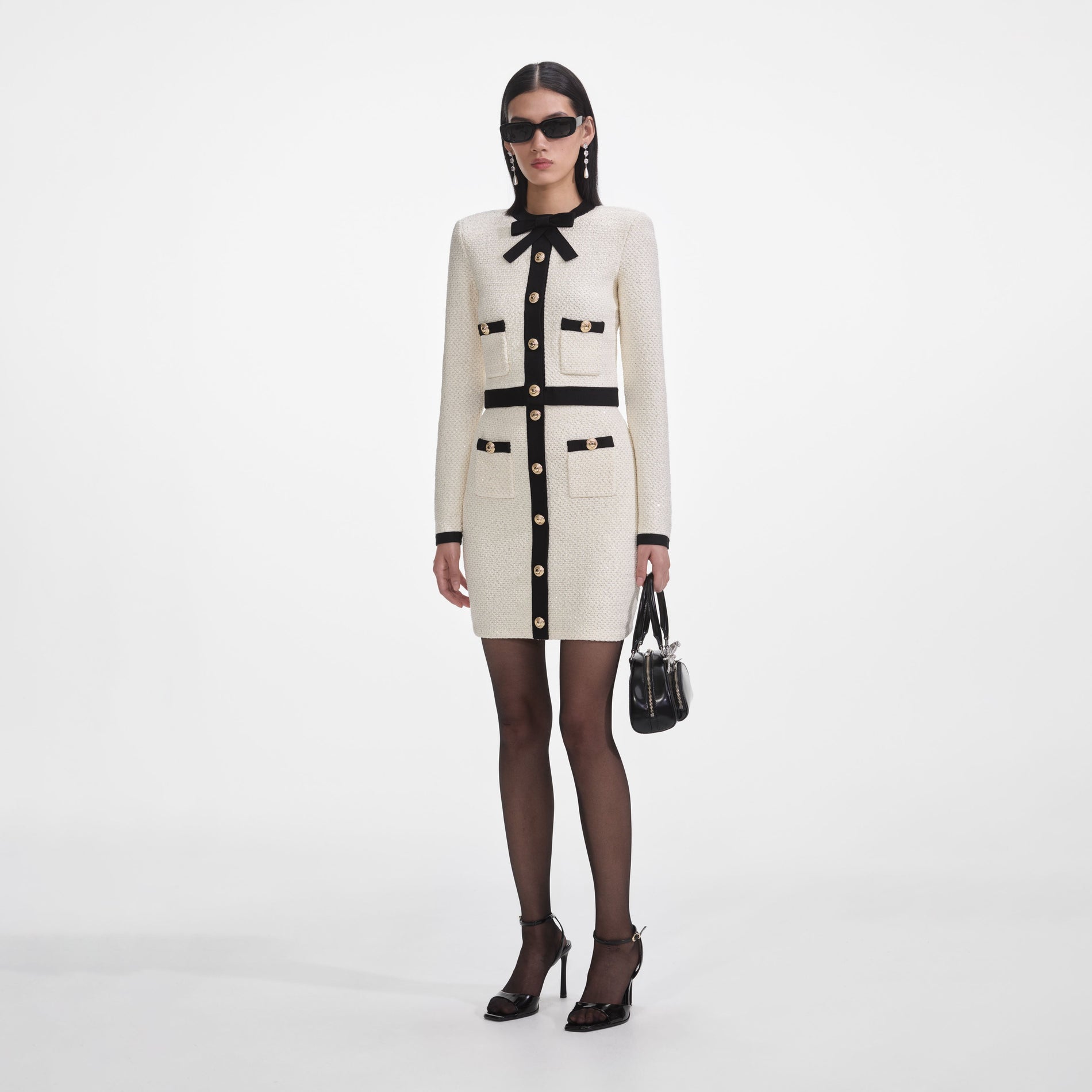 Side view of a woman wearing the Cream Sequin Knit Mini Skirt