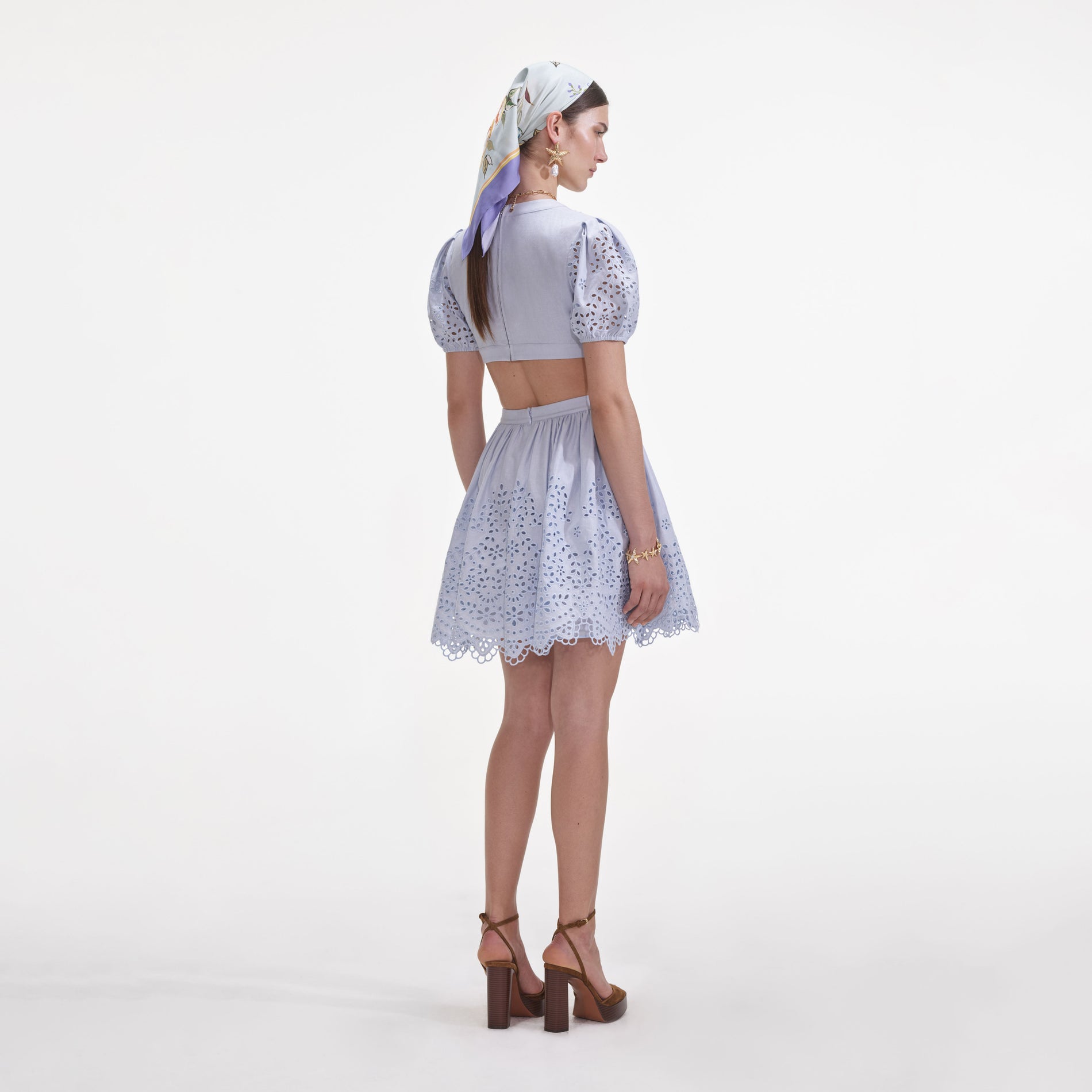 Back view of a woman wearing the Blue Embroidered Linen Mini Dress