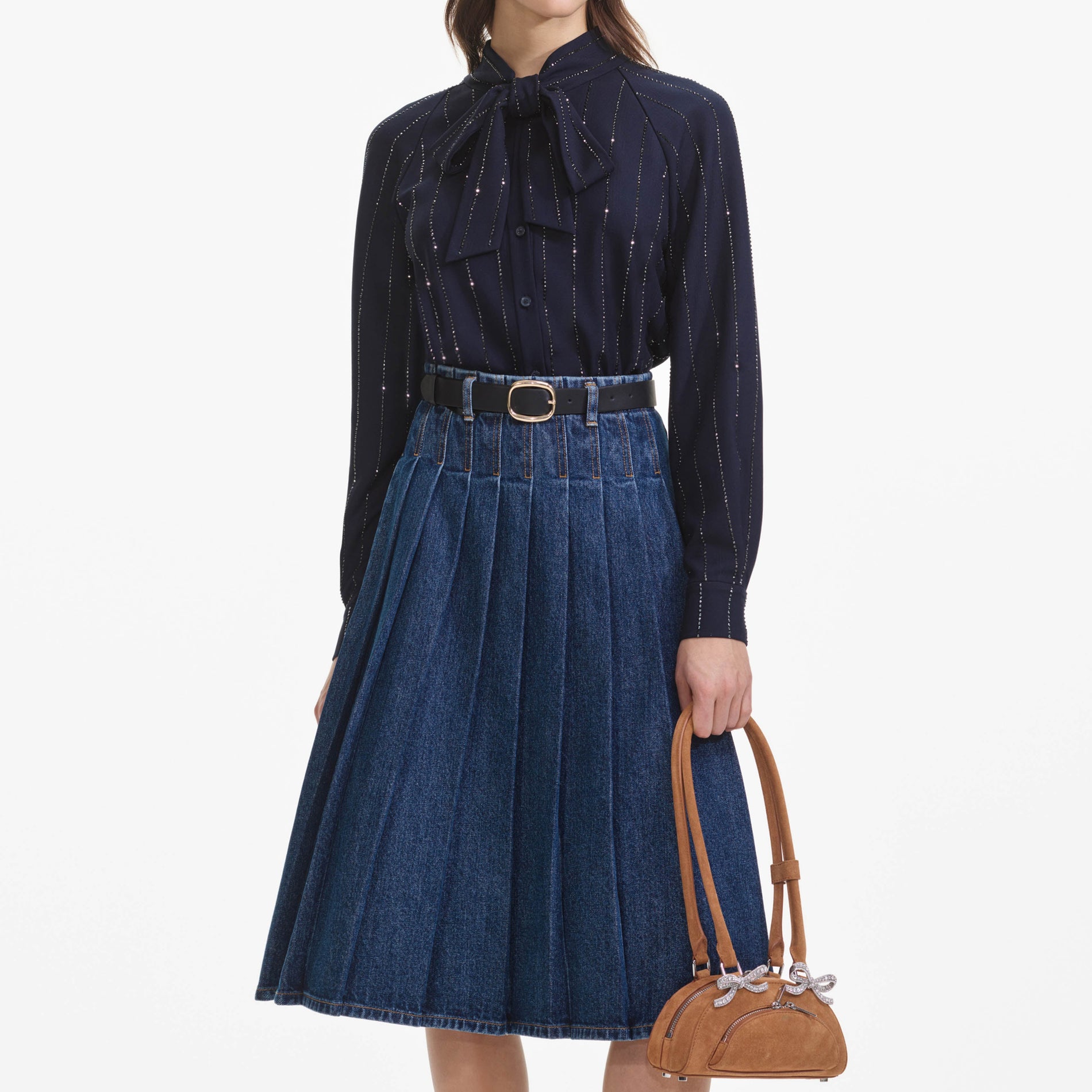 A close up of a woman wearing the Pleated Denim Midi Skirt