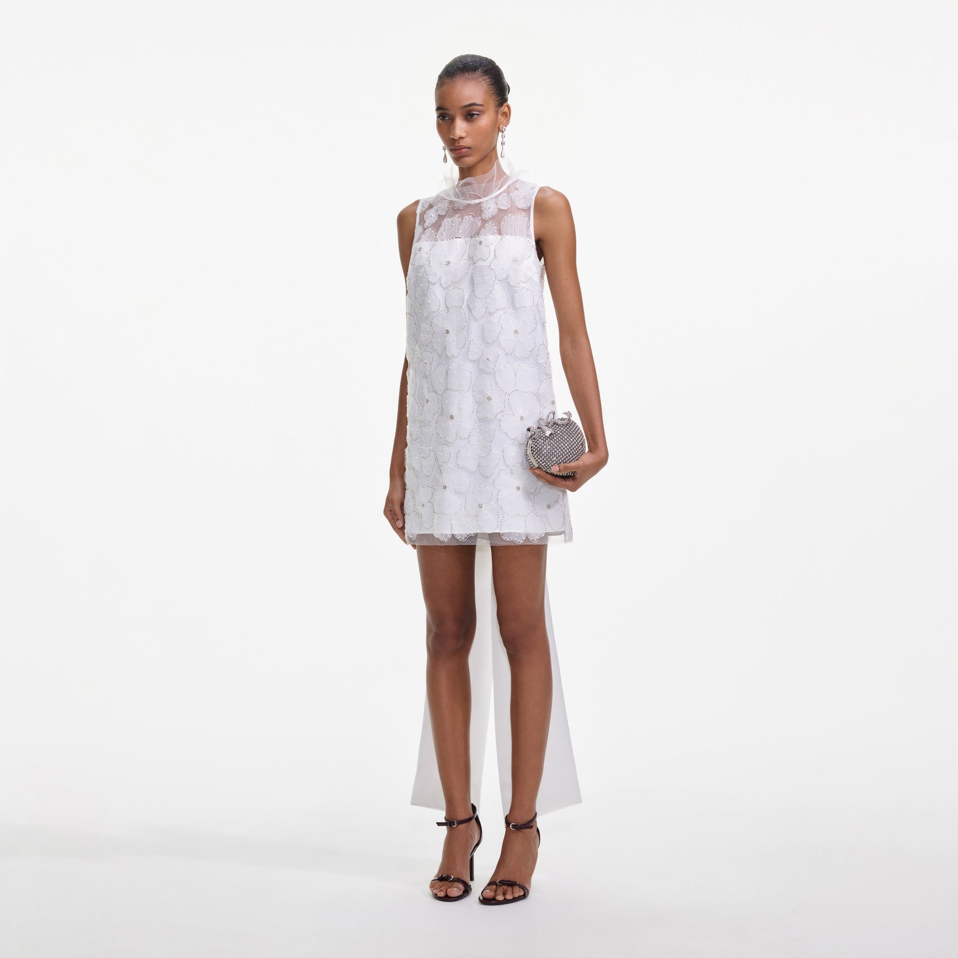 Side view of a woman wearing the White Tulle Satin Bow Mini Dress