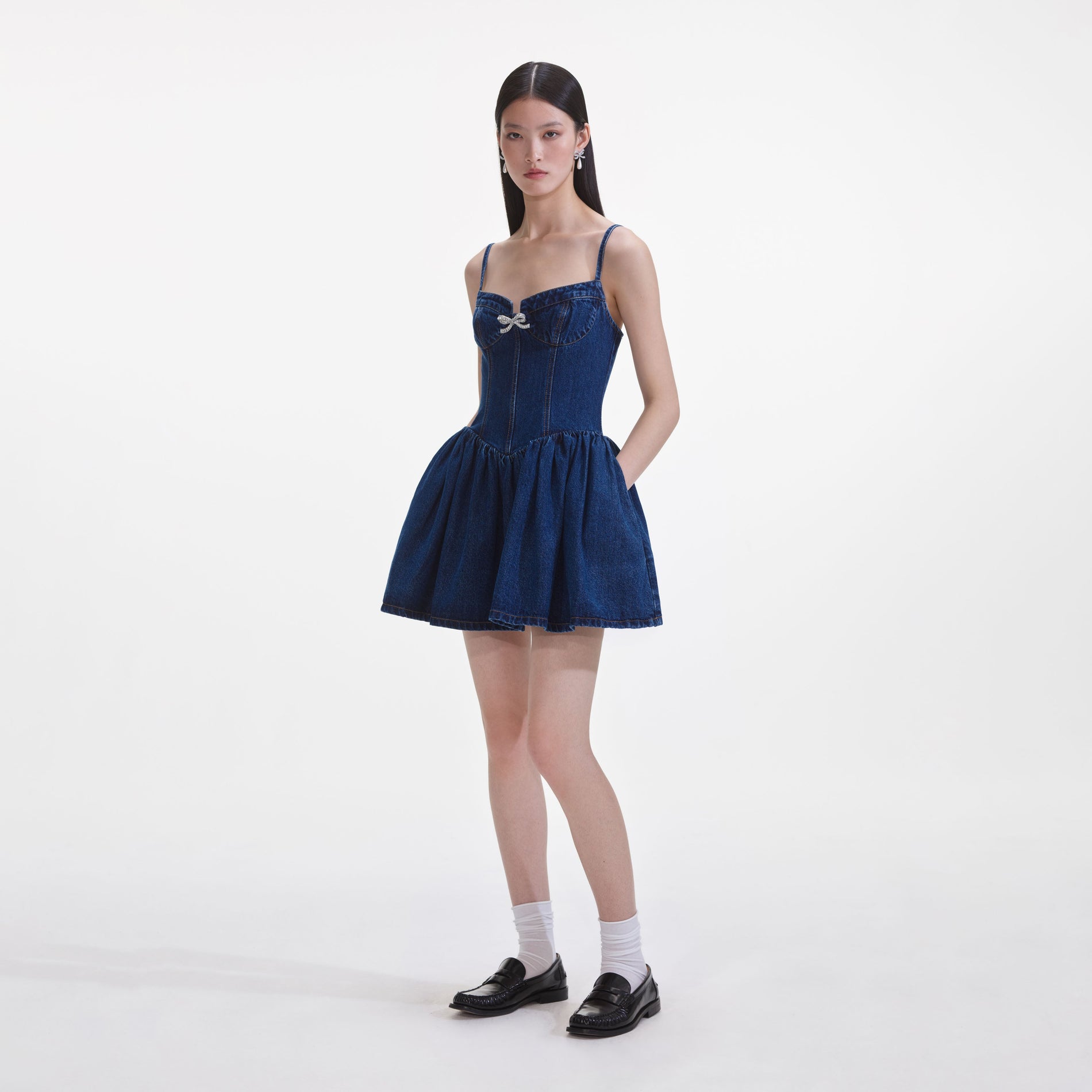 Side view of a woman wearing the Denim Diamante Bow Sweetheart Mini Dress
