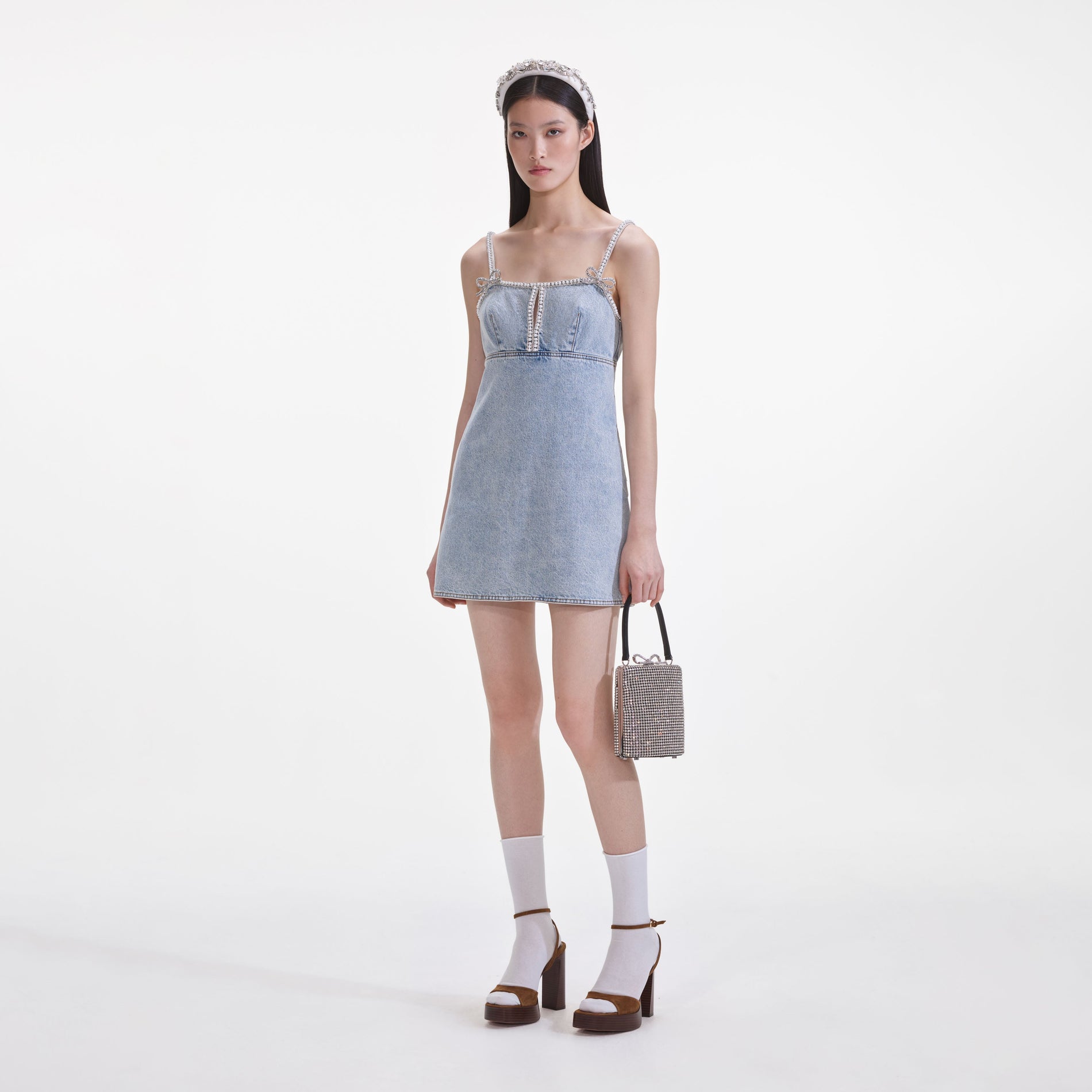 Side view of a woman wearing the Light Blue Denim Pearl Mini Dress