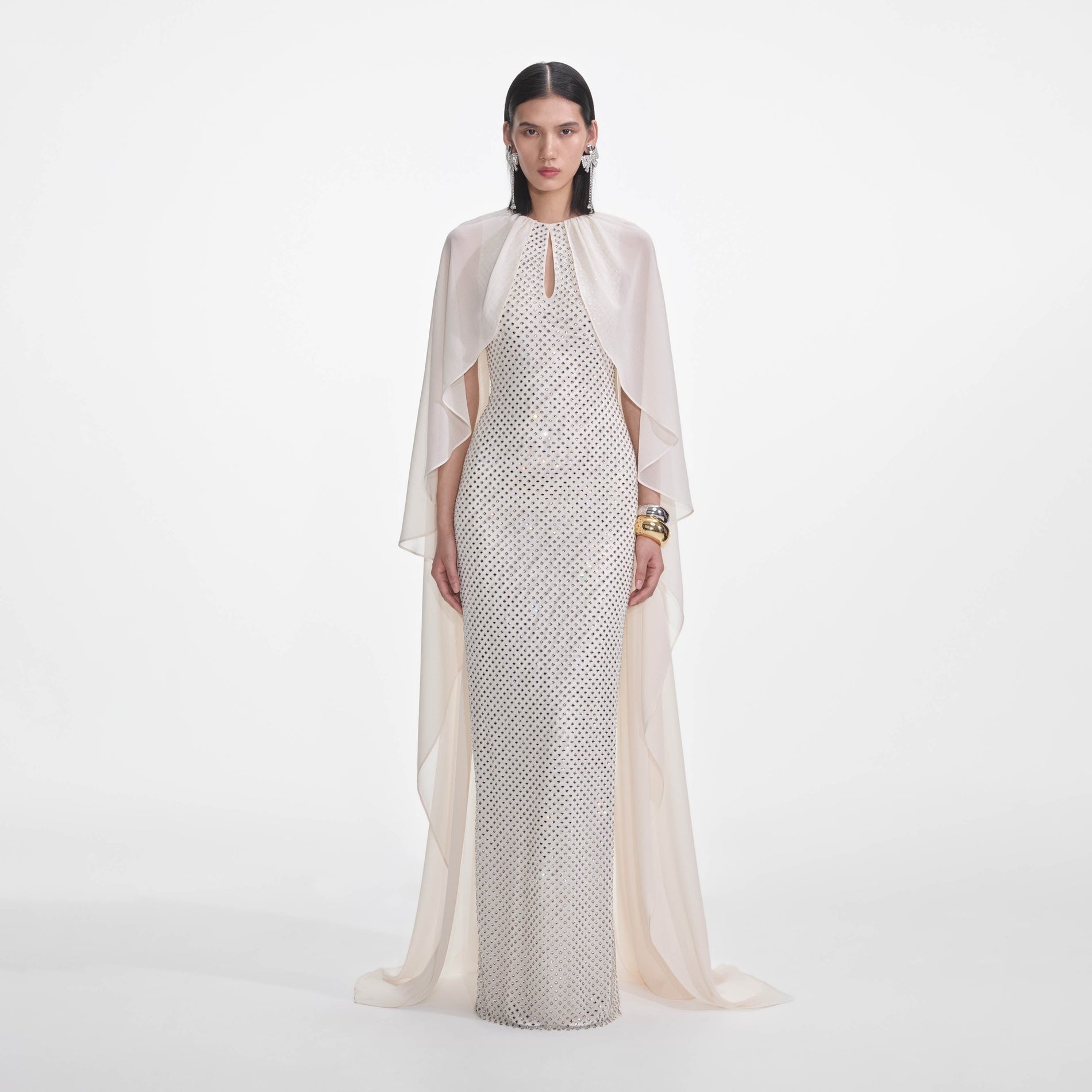 Front view of a woman wearing the Cream Rhinestone Cape Maxi Dress