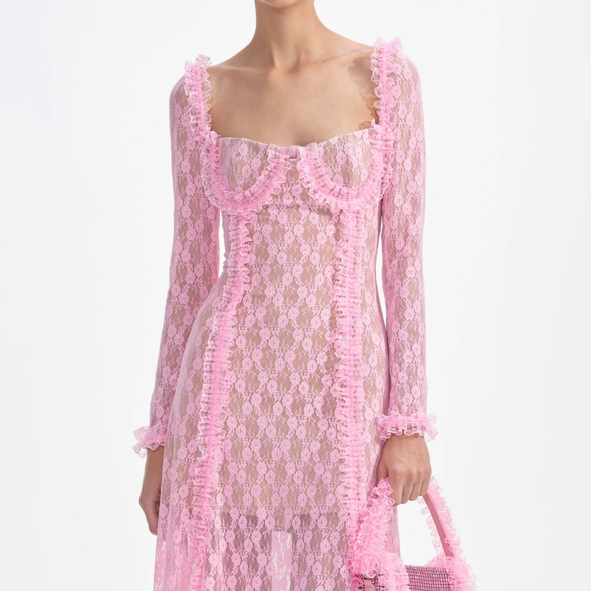 A close up of a woman wearing the Pink Lace Ruffle Midi Dress