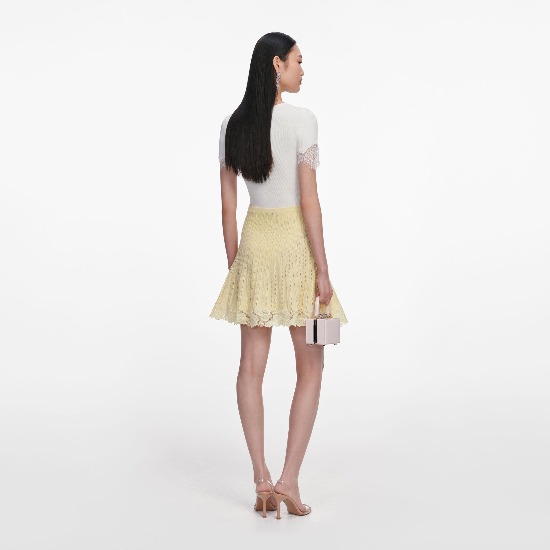 Back view of a woman wearing the Yellow Pointelle Knit Mini Skirt