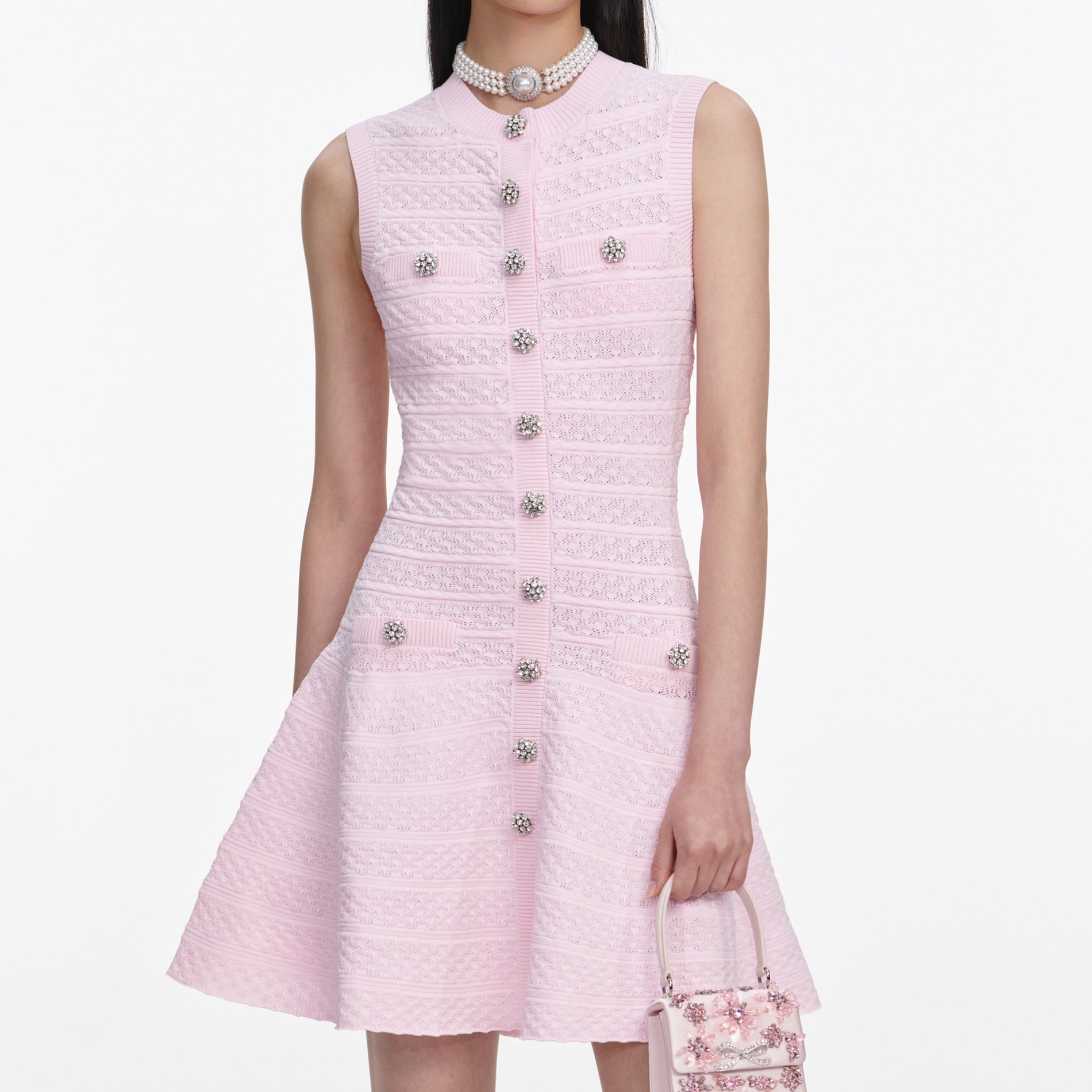 A close up of a woman wearing the Pink Pointelle Diamante Knit Mini Dress