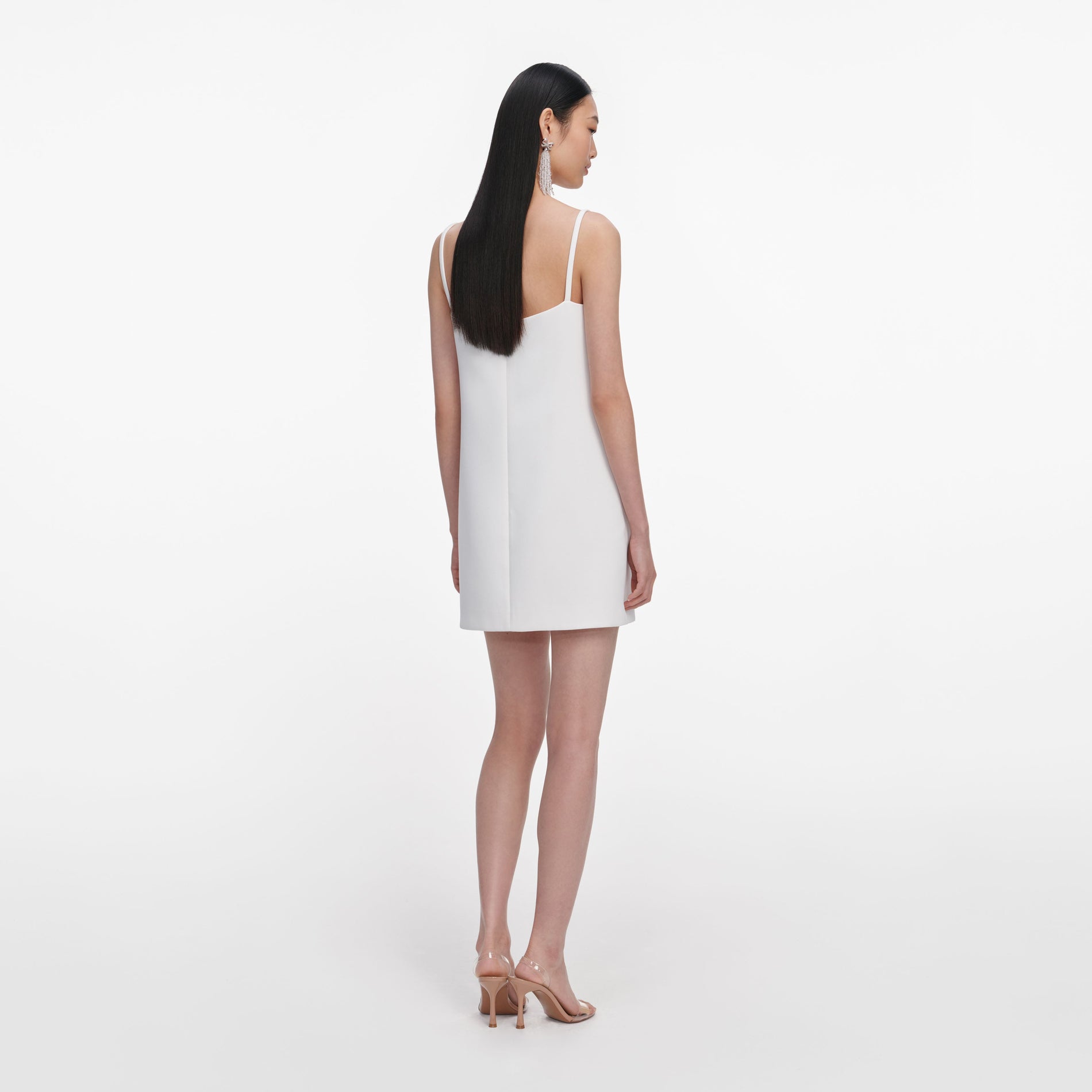Back view of a woman wearing the White Crepe 3D Sequin Flower Mini Dress