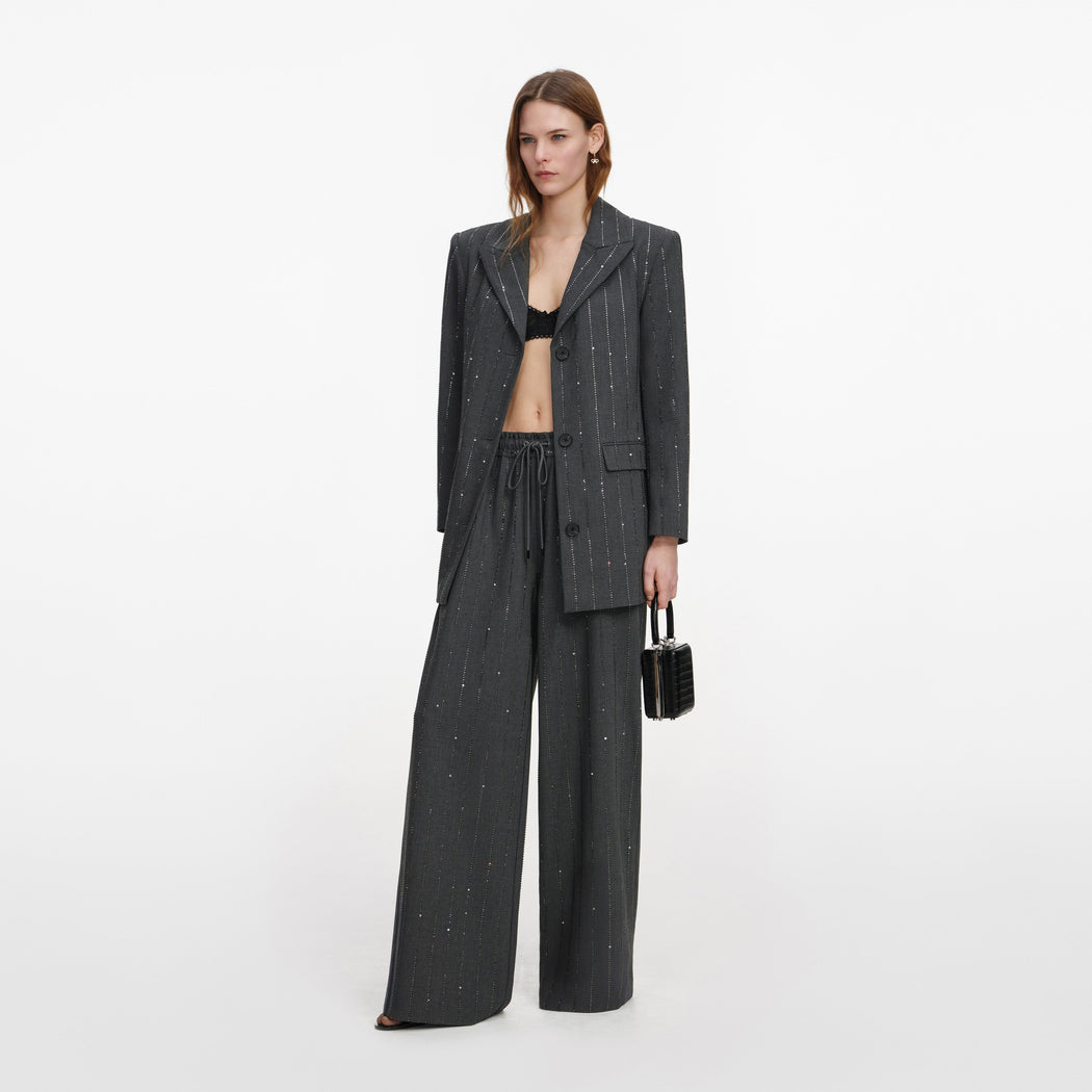 Side view of a woman wearing the Grey Rhinestone Pinstripe Trousers