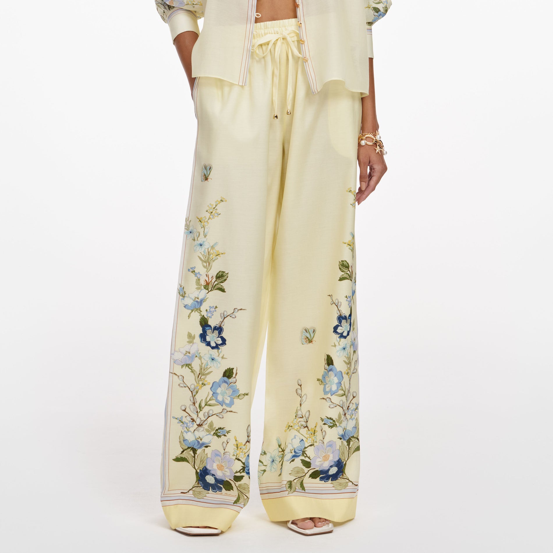 A close up of a woman wearing the Yellow Floral Organza Trousers