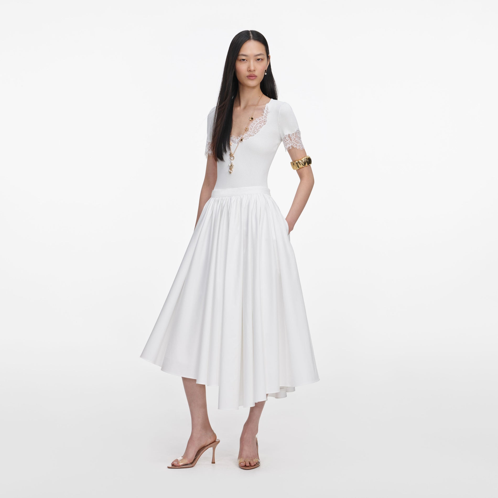 Side view of a woman wearing the White Cotton Poplin Midi Skirt