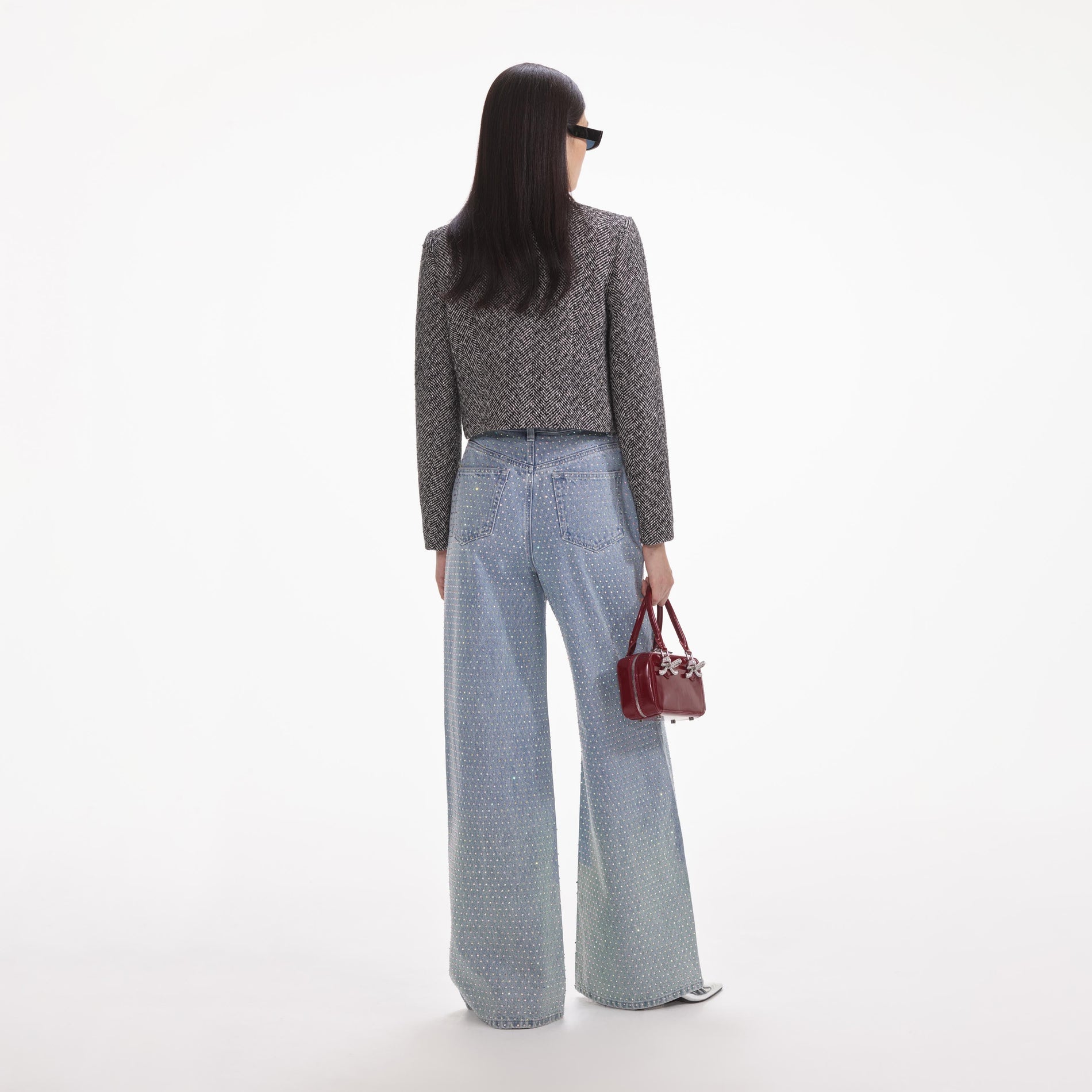 Back view of a woman wearing the White Rhinestone Ombre Distressed Jeans