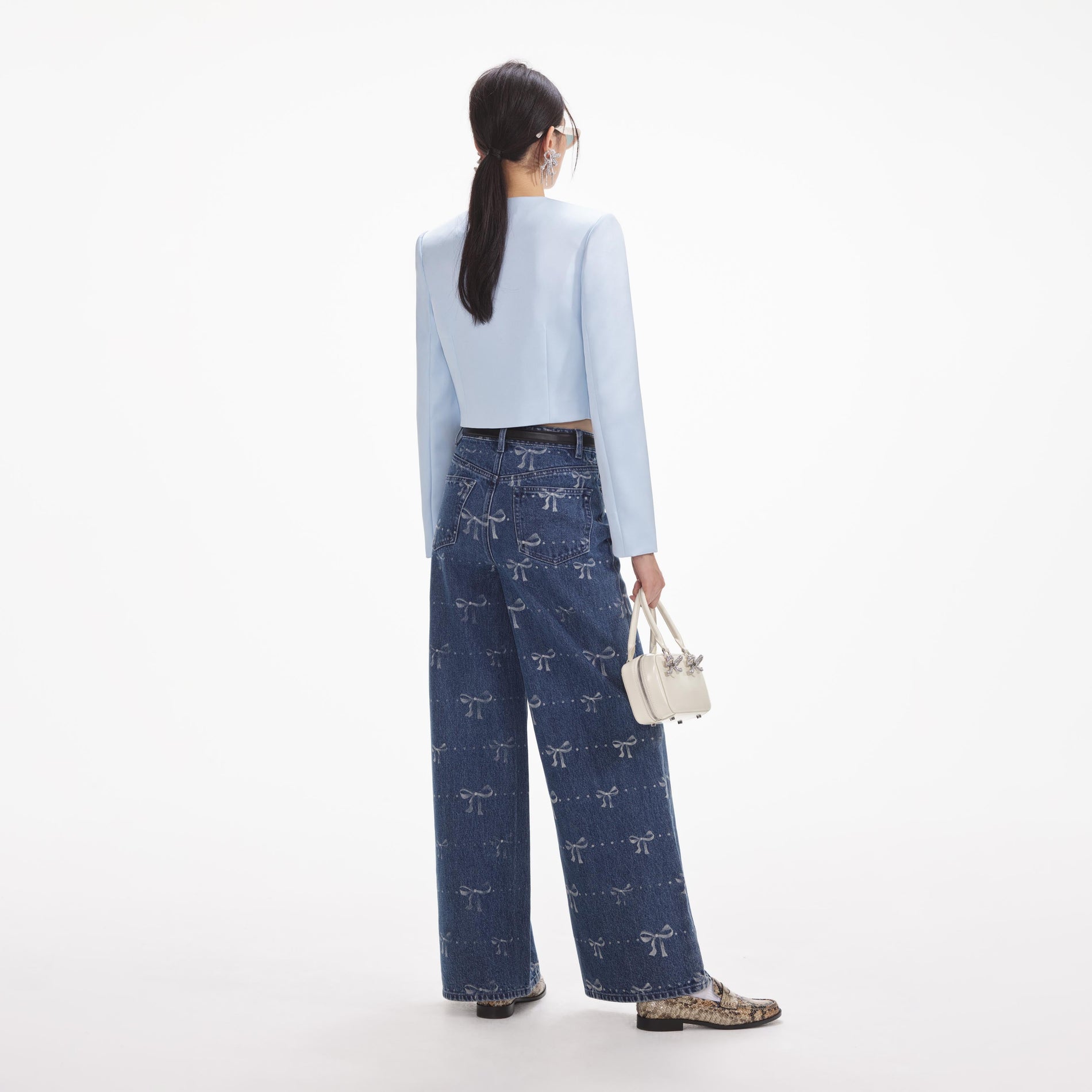 Back view of a woman wearing the White Bow Print Jeans