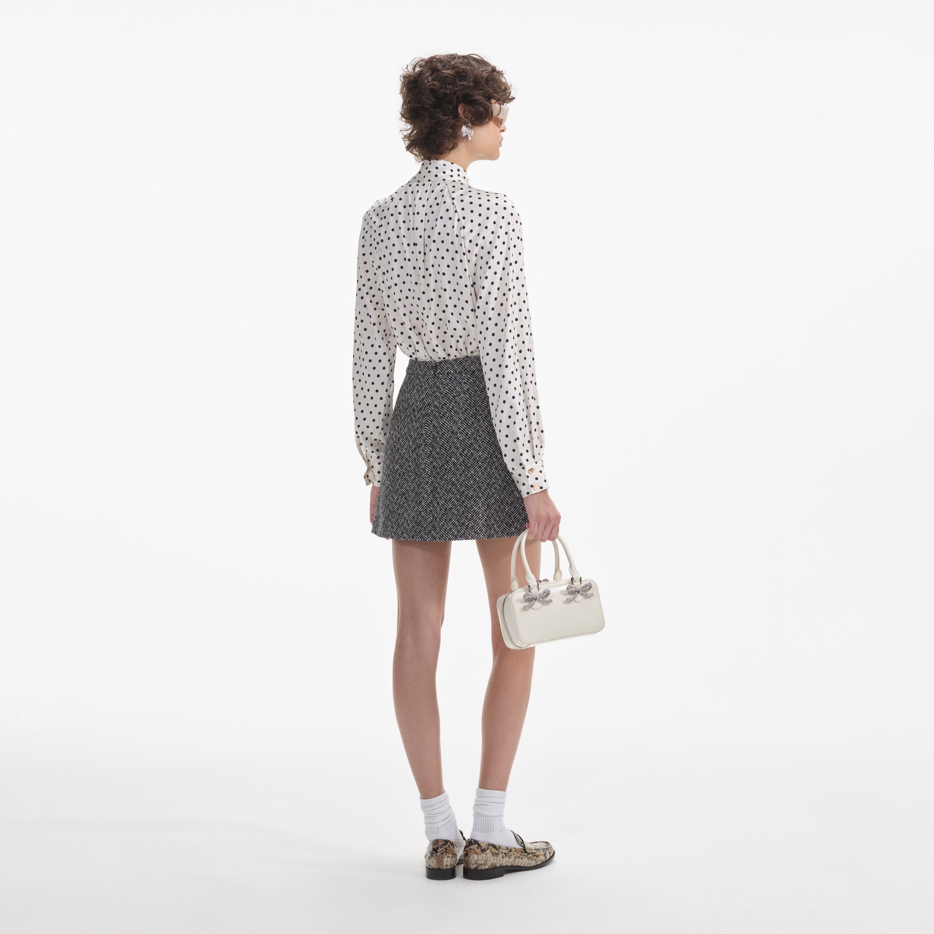 Back view of a woman wearing the White Black Herringbone Mini Skirt