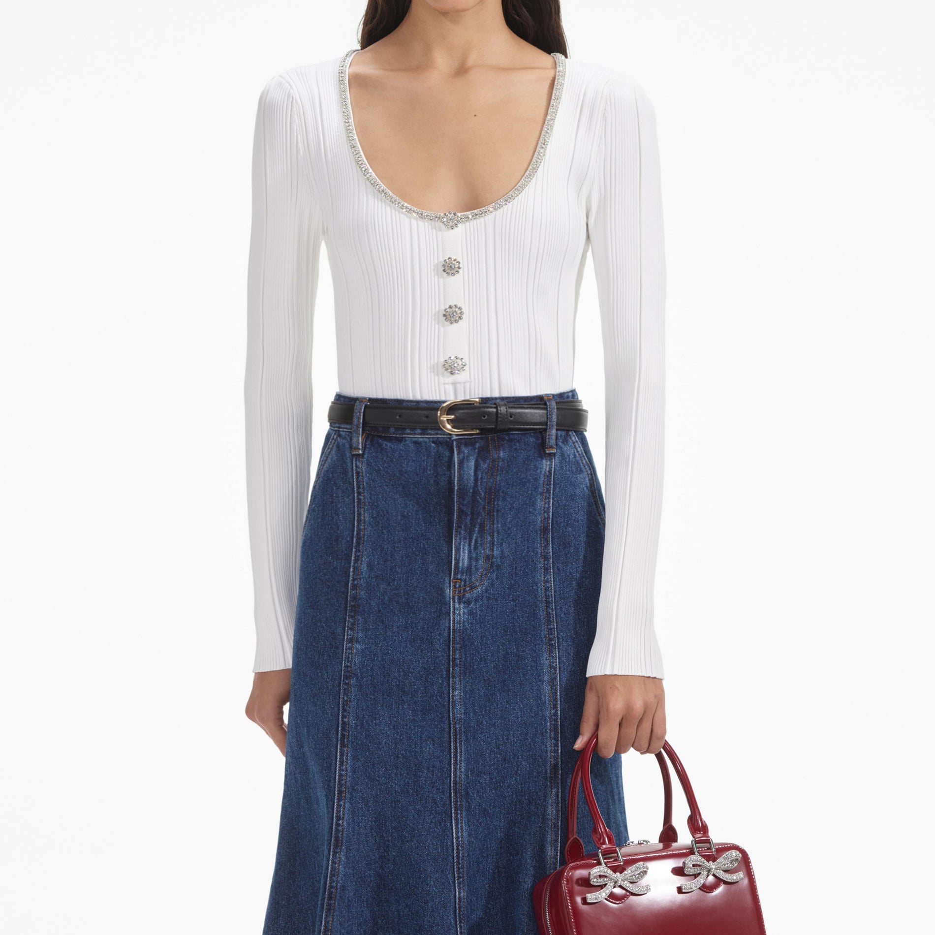 A close up of a woman wearing the White Embellished Knit Top