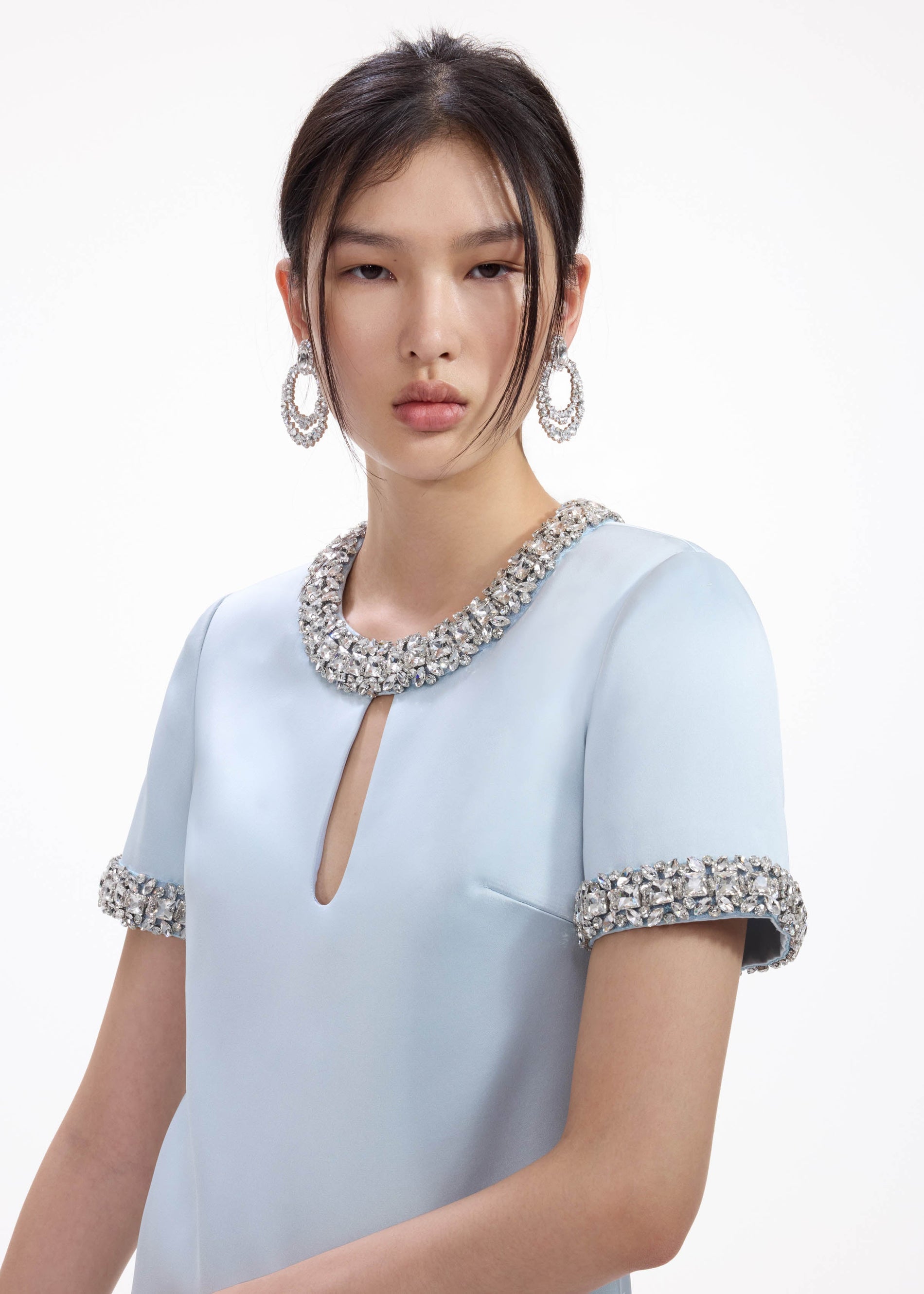 A close up of a woman wearing the Crystal Double Hoop Earrings